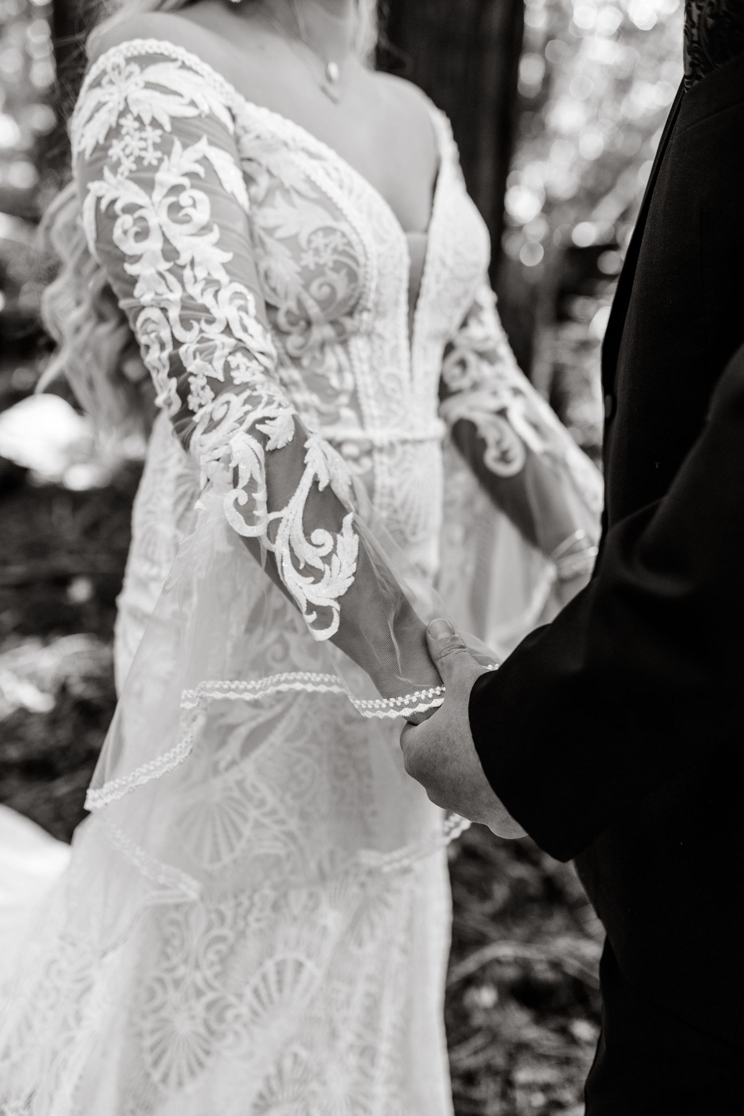 Close-up of delicate lace wedding dress details in black and white.
