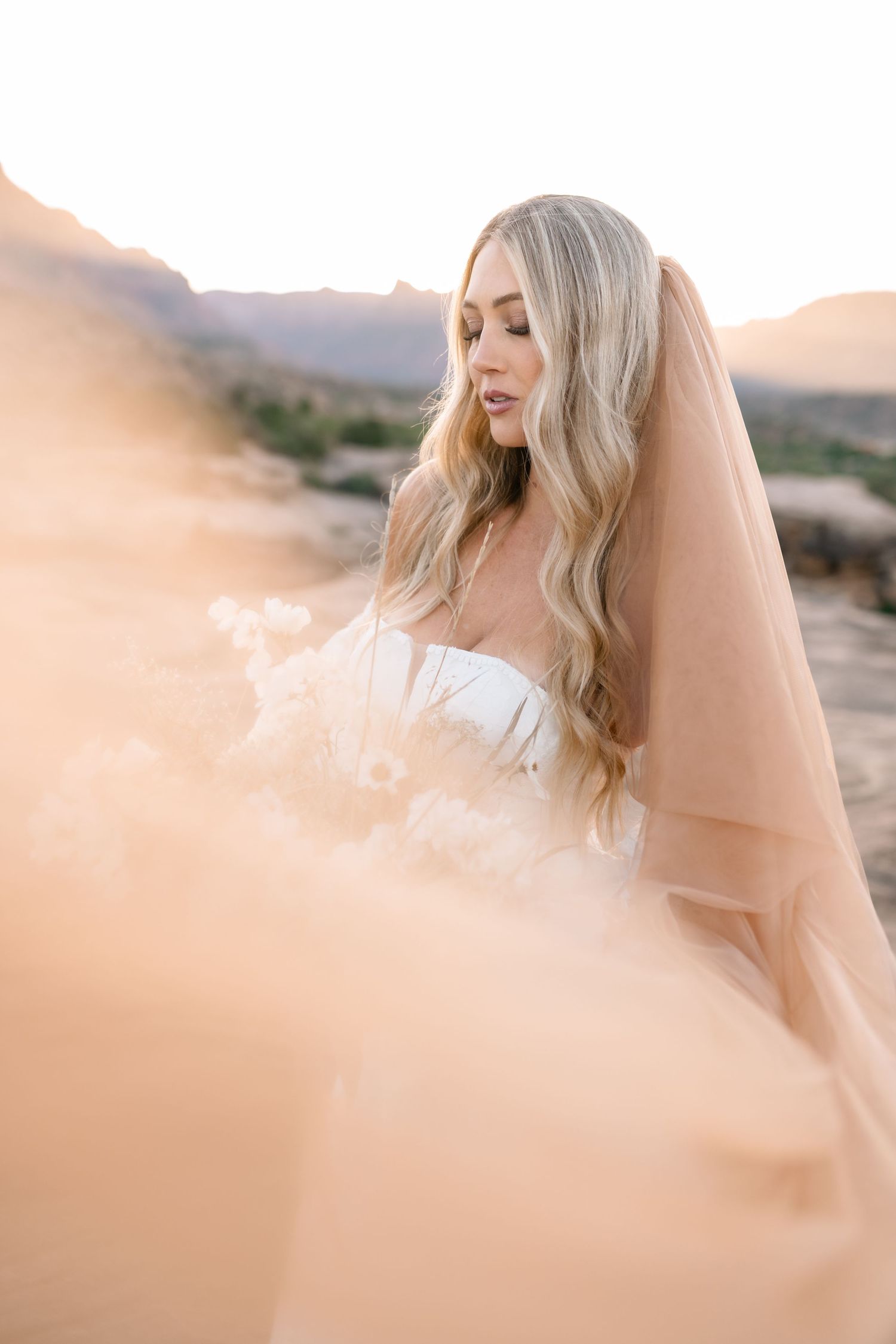 Zions wedding photographer takes beautiful desert sunrise bridals featuring a unique veil and dried floral bouquet.