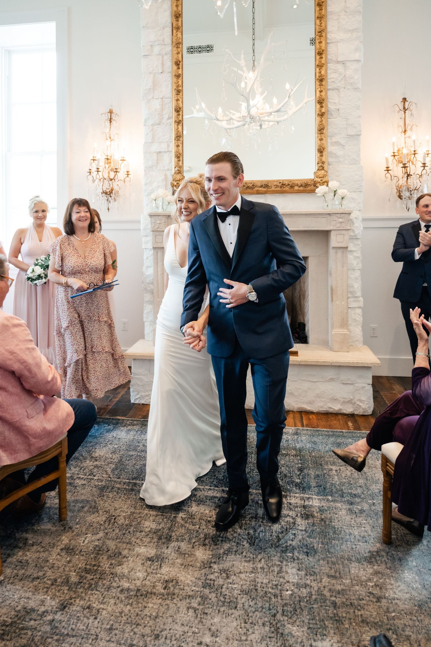 Wedding celebration in an elegant room with guests watching a playful shoe game.