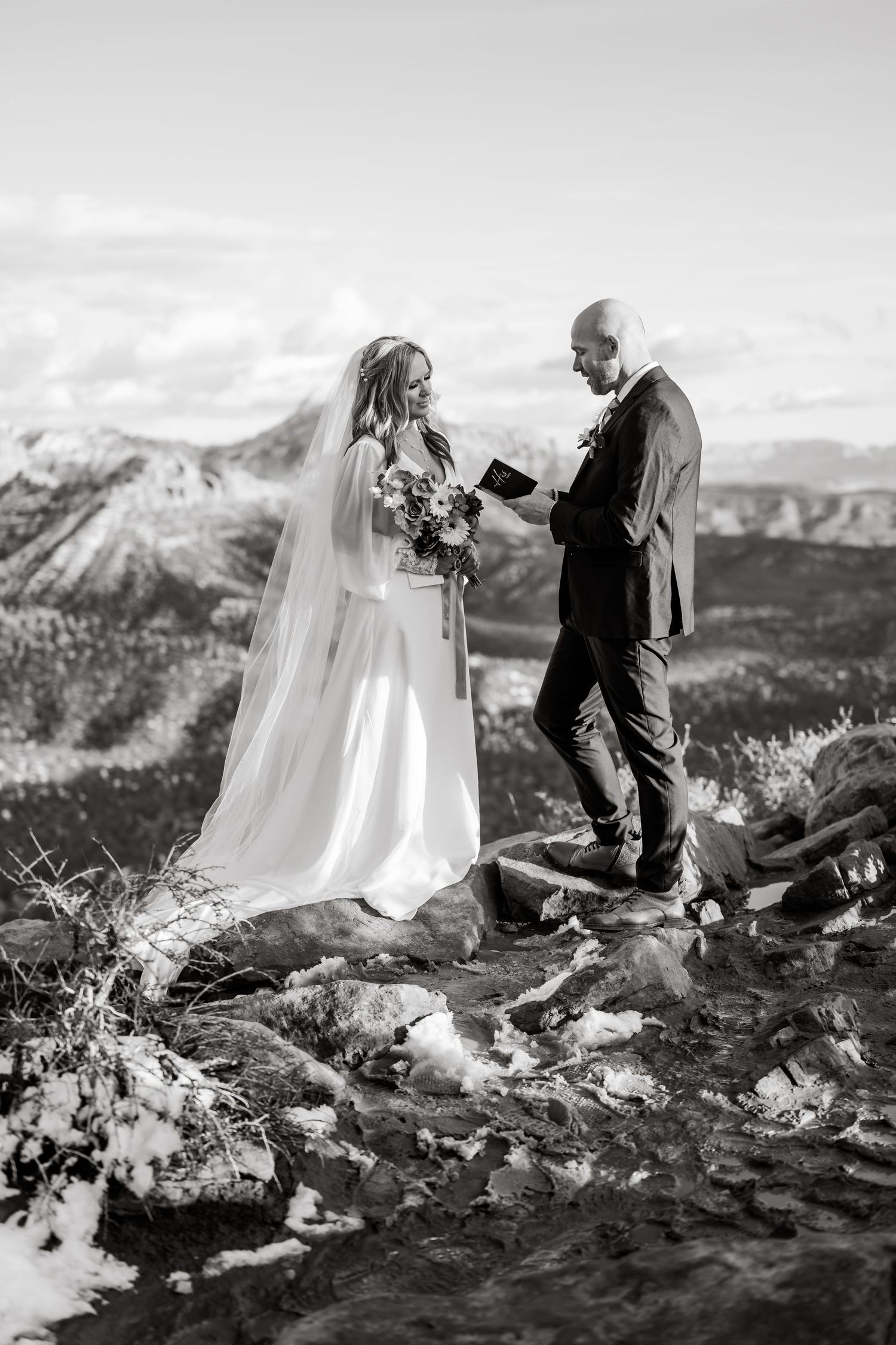 Black and white photo of wedding ceremony on mountain peak.