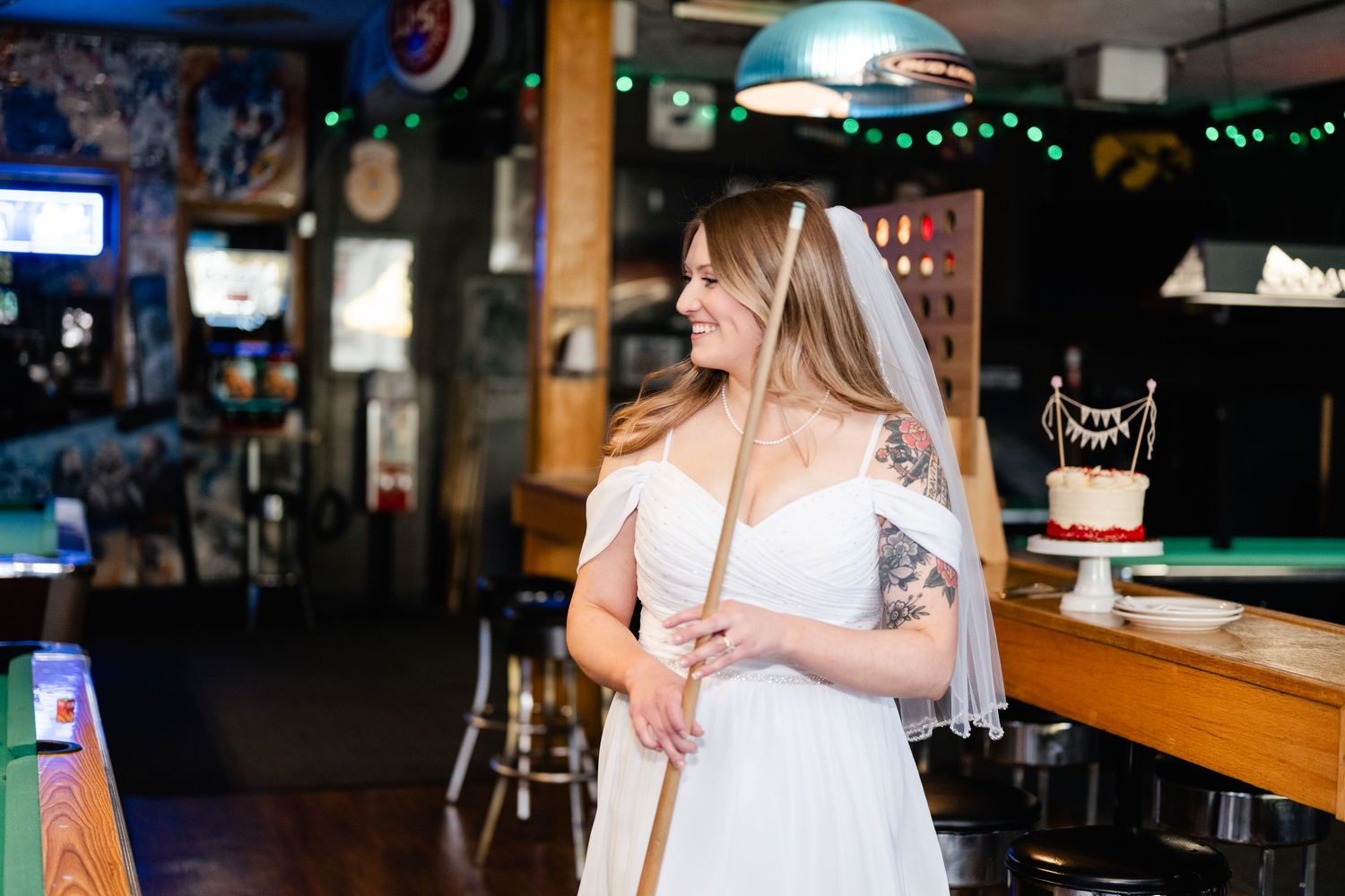Wedding celebration in a bar with pool tables and festive decorations.
