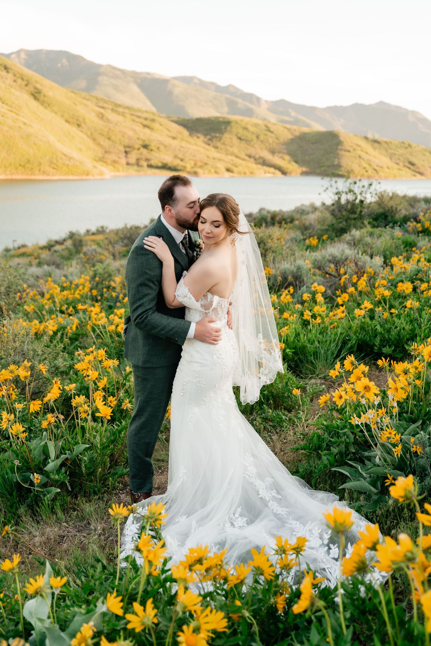 Wedding portraits in a stunning mountain meadow filled with bright yellow spring flowers at golden hour.