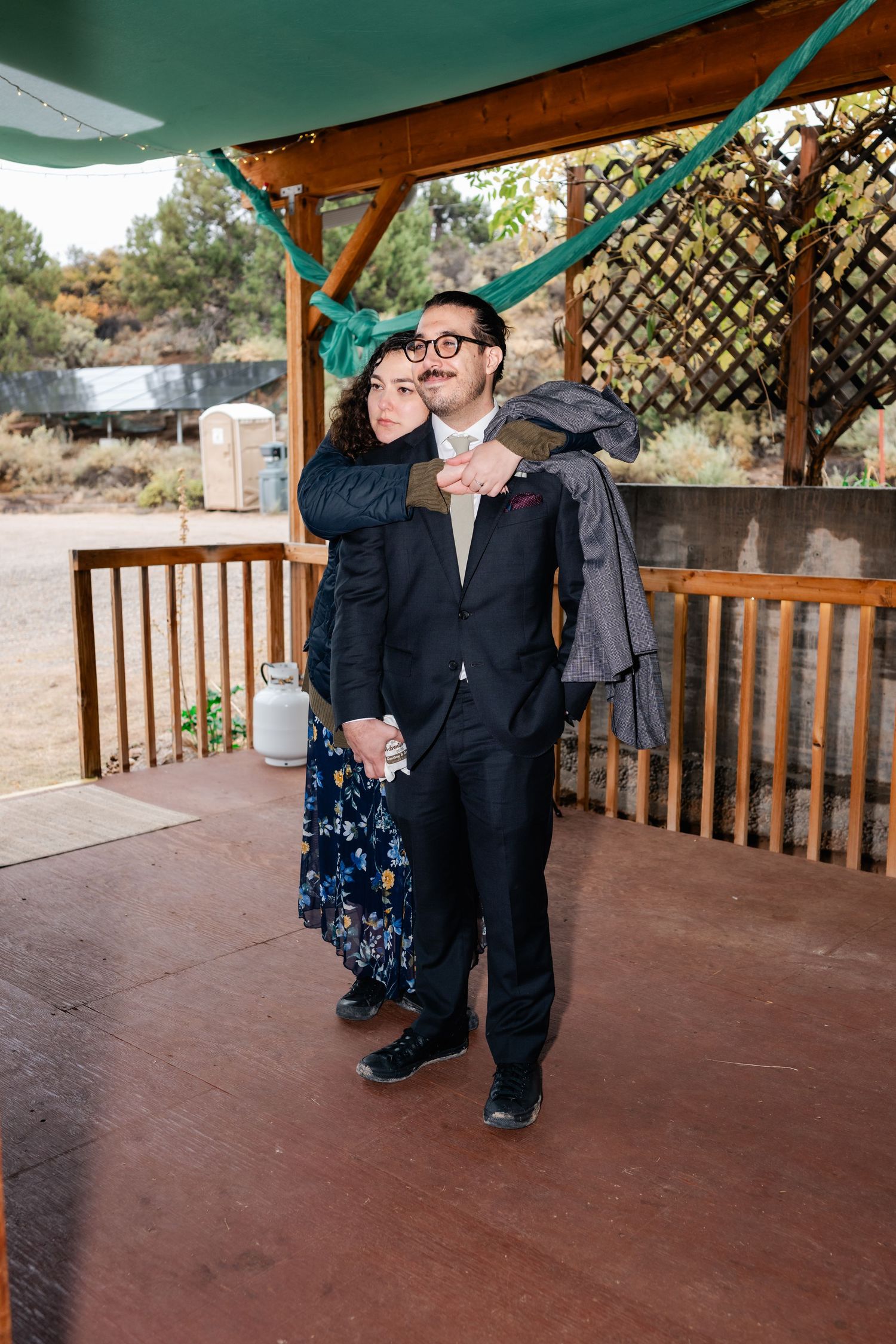 People dancing and celebrating at a rustic outdoor wedding venue with wooden railings.