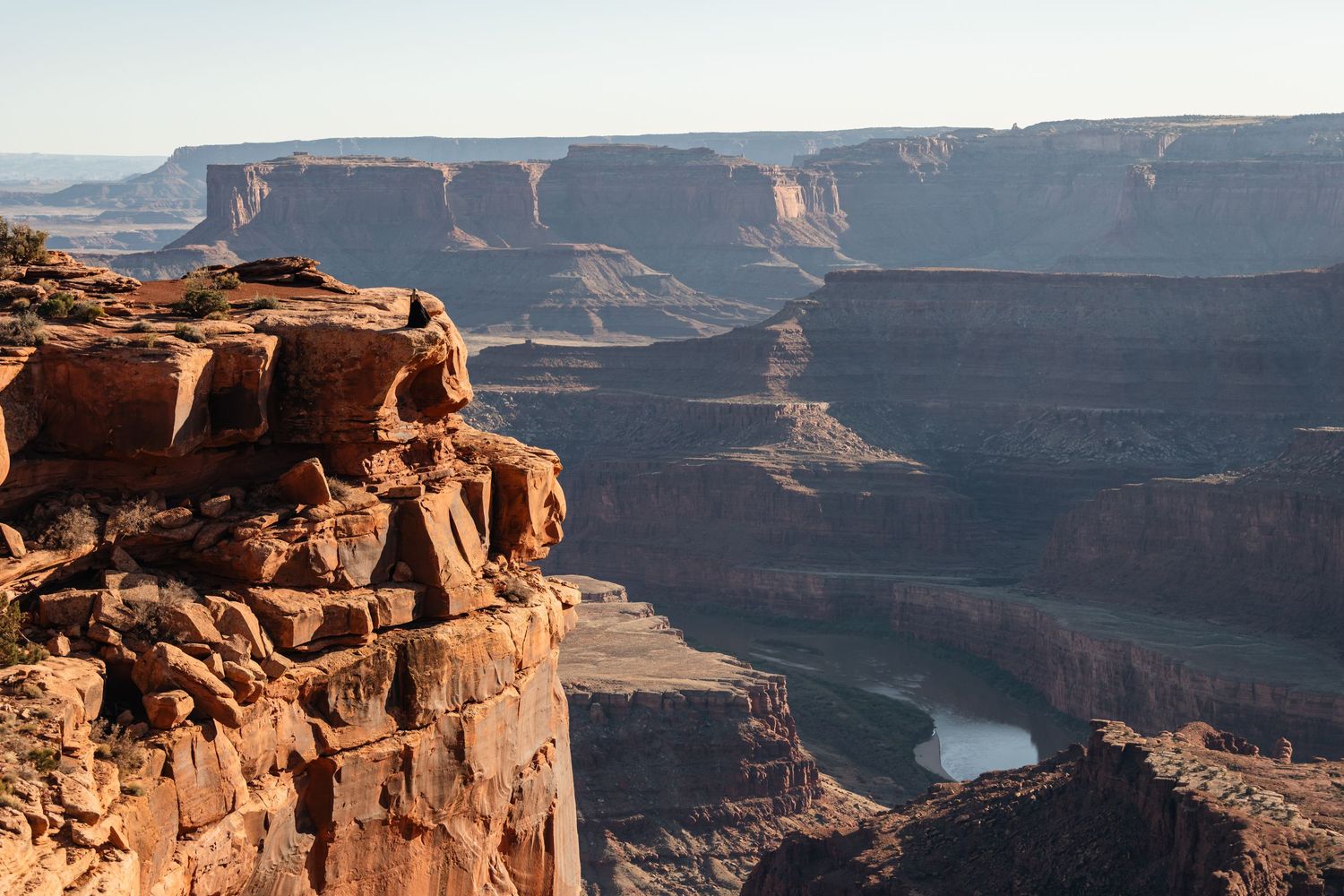 Scenic view of red rock cliffs overlooking the winding Colorado River in Dead Horse Point State Park, Utah.