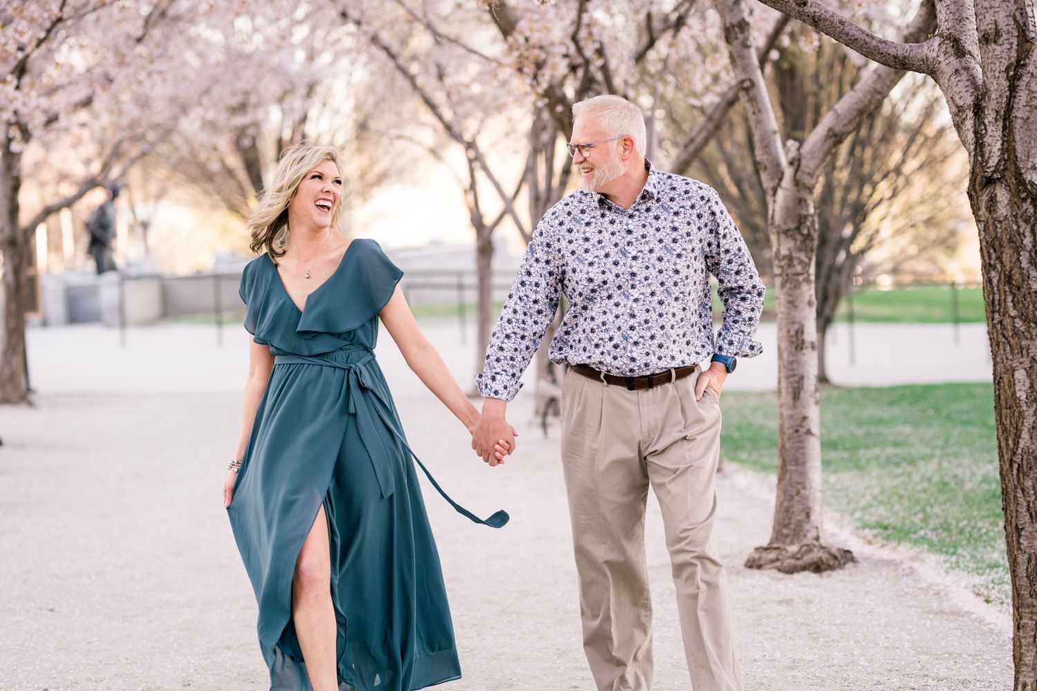 Engaged couple holding hands at the Capitol cherry blossoms by timeless wedding photographer Coley Cook