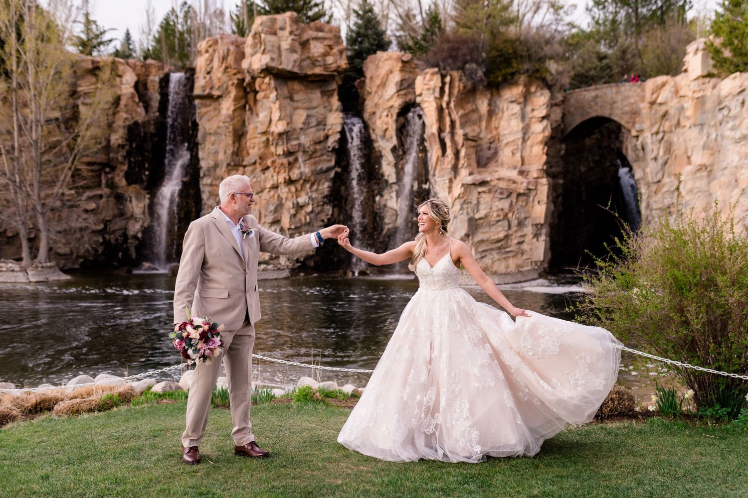 A couple shares a dance by waterfalls during their wedding photoshoot. Thanksgiving Point, a Utah County wedding venue.