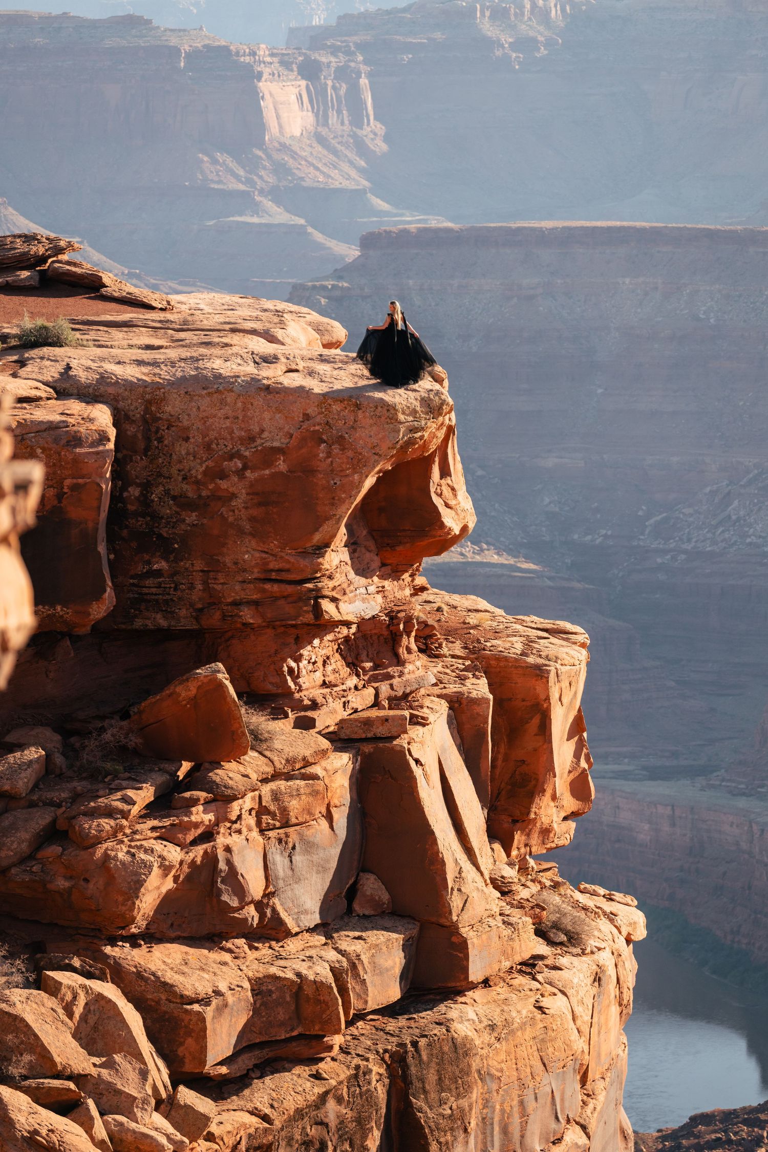 A series of photos showing a person sitting precariously on the edge of red rock cliffs overlooking Lake Powell's blue waters.