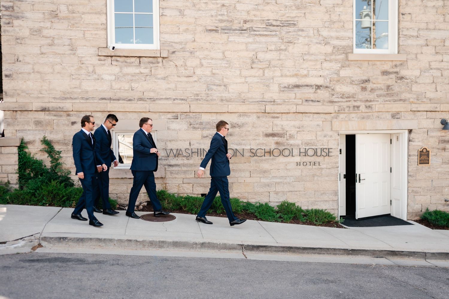 Group gathered outside a historic brick building with classic architectural details.