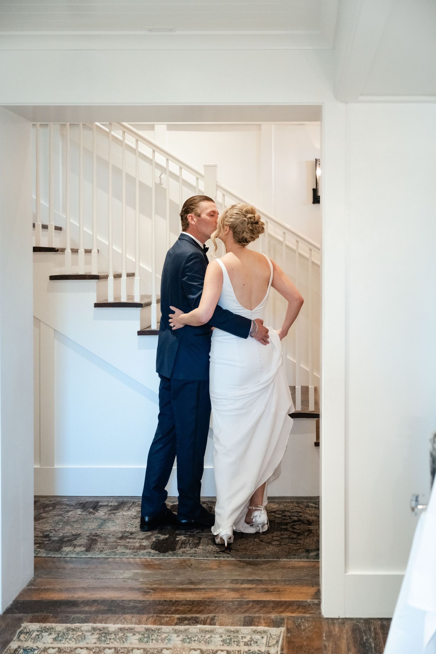 Couple ascends a white staircase together in a series of romantic wedding day portraits.