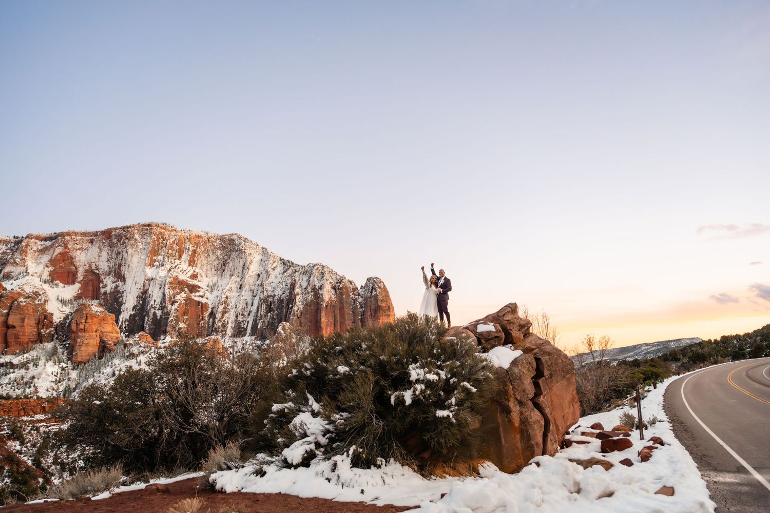 Wide landscape shot of snow-covered desert terrain with distant red rock formations.
