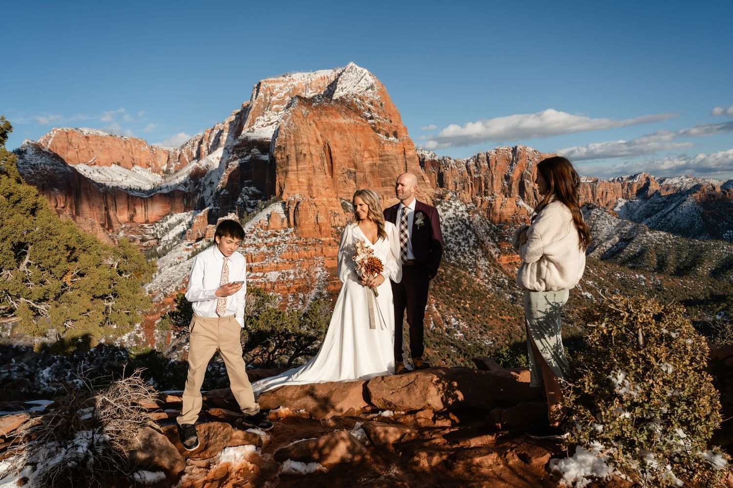 Desert wedding ceremony with dramatic red rock formations and blue sky backdrop.