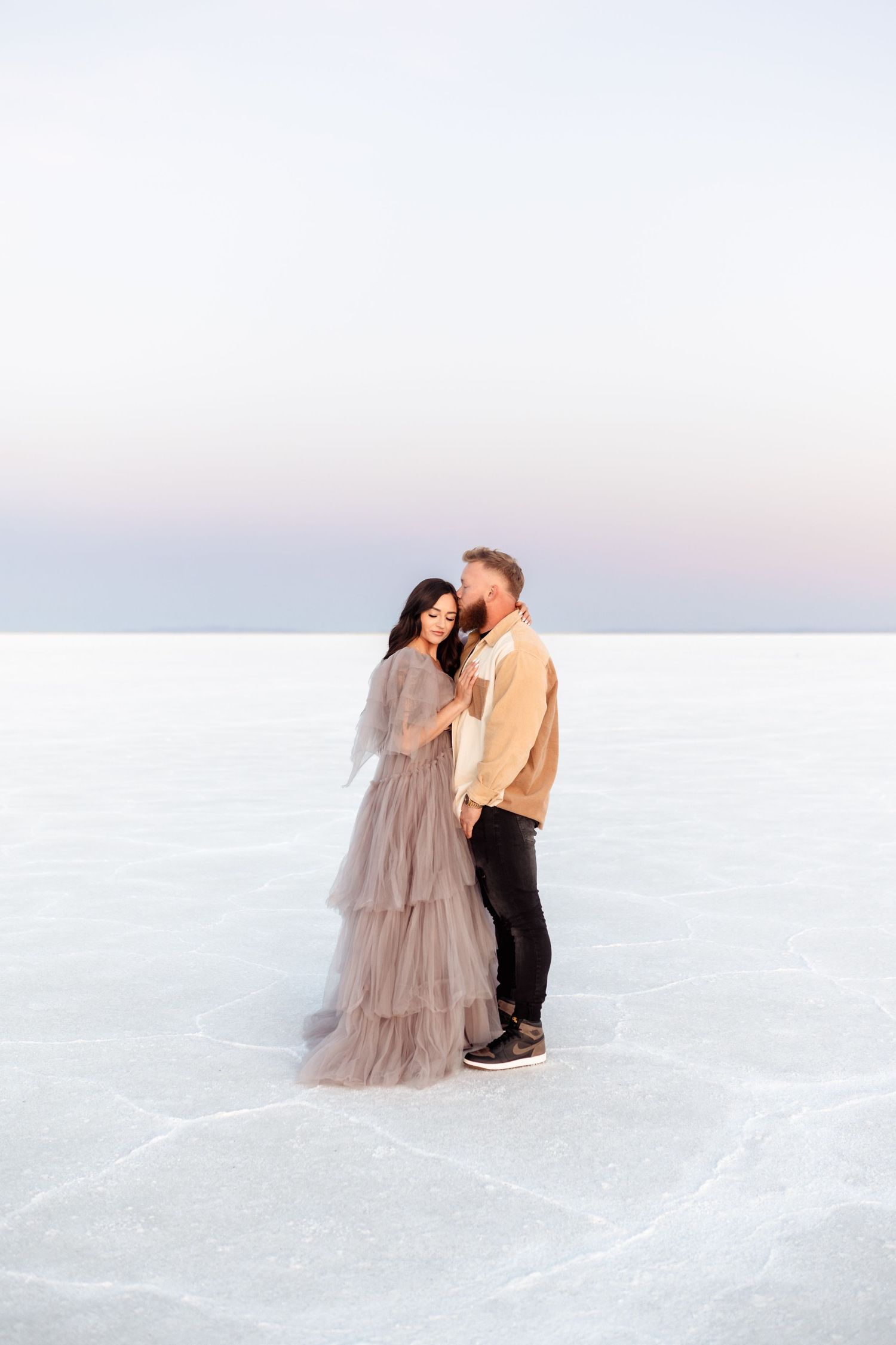 Couple hold each other during Salt Flats photos by Utah couples photographer during sunset