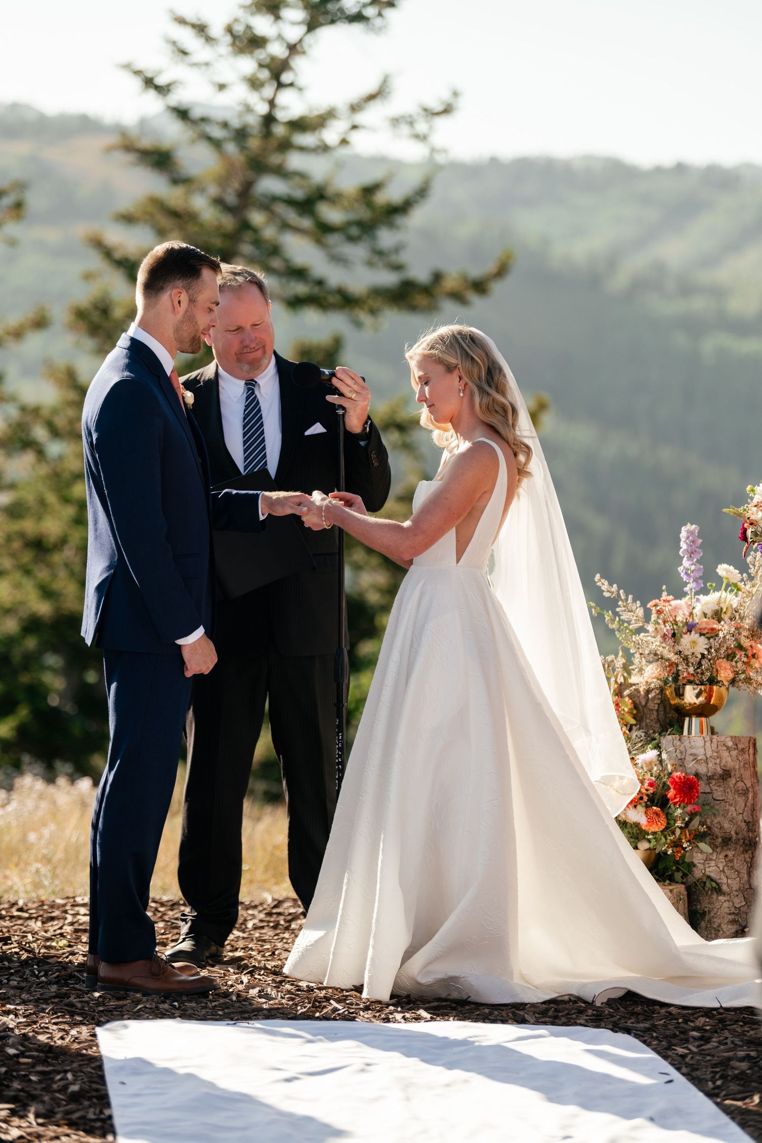 Wedding ceremony taking place on a scenic mountaintop with stunning valley views.