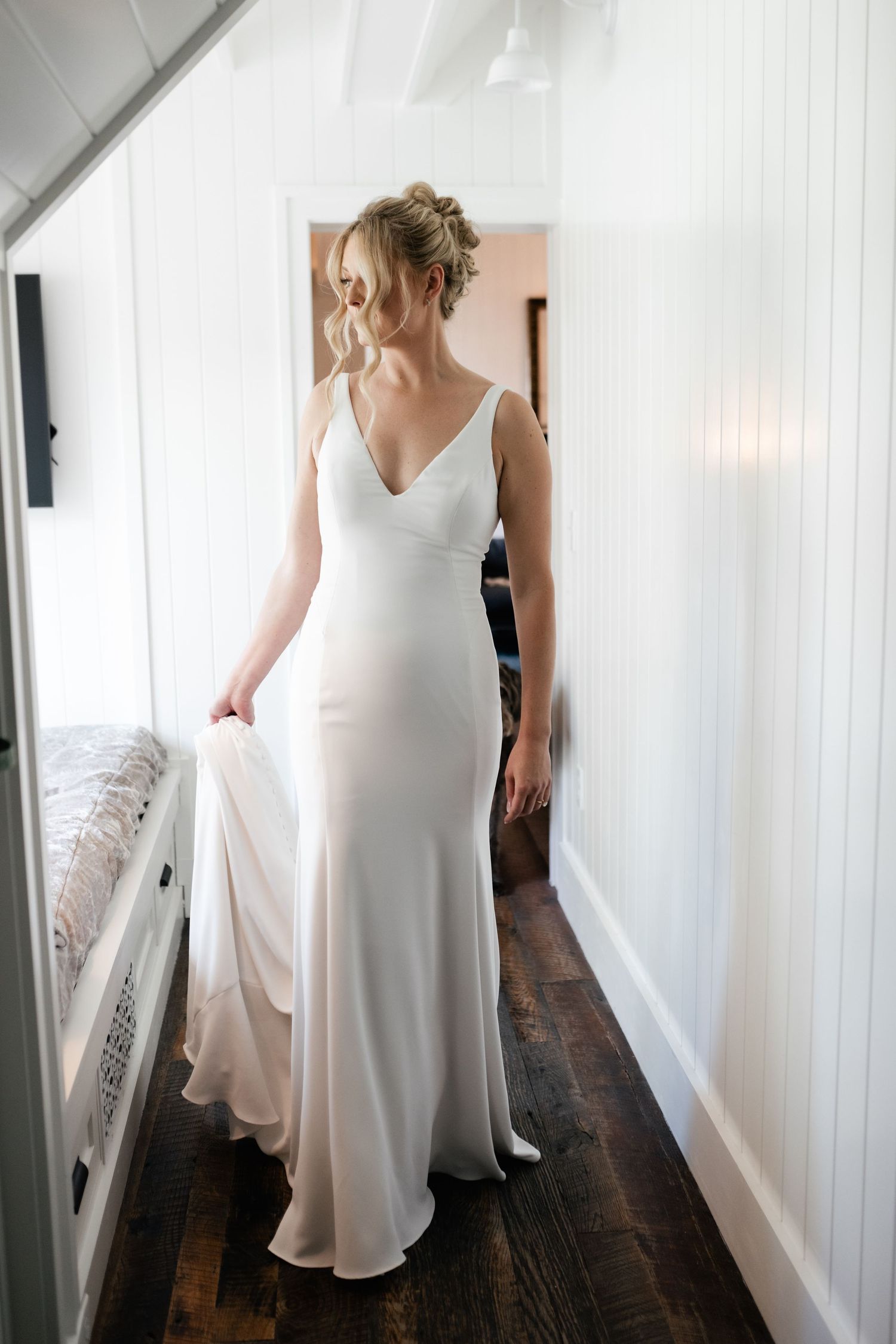 Elegant white wedding dress shown from different angles in hallway.