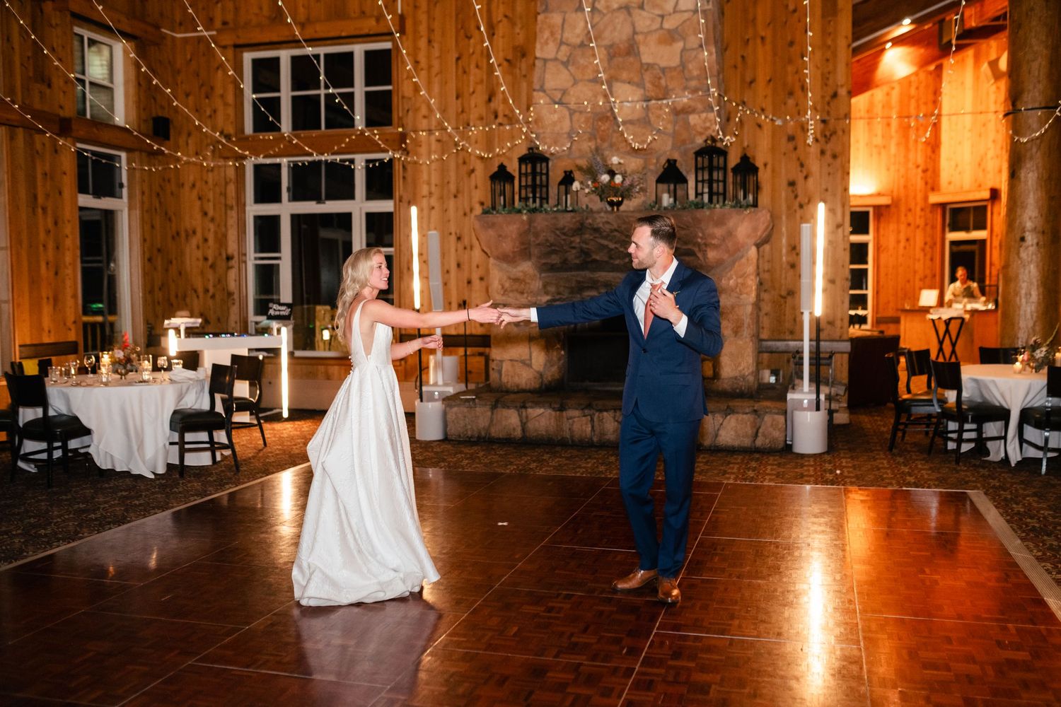 Wedding reception in a rustic venue with wooden beams and warm lighting.