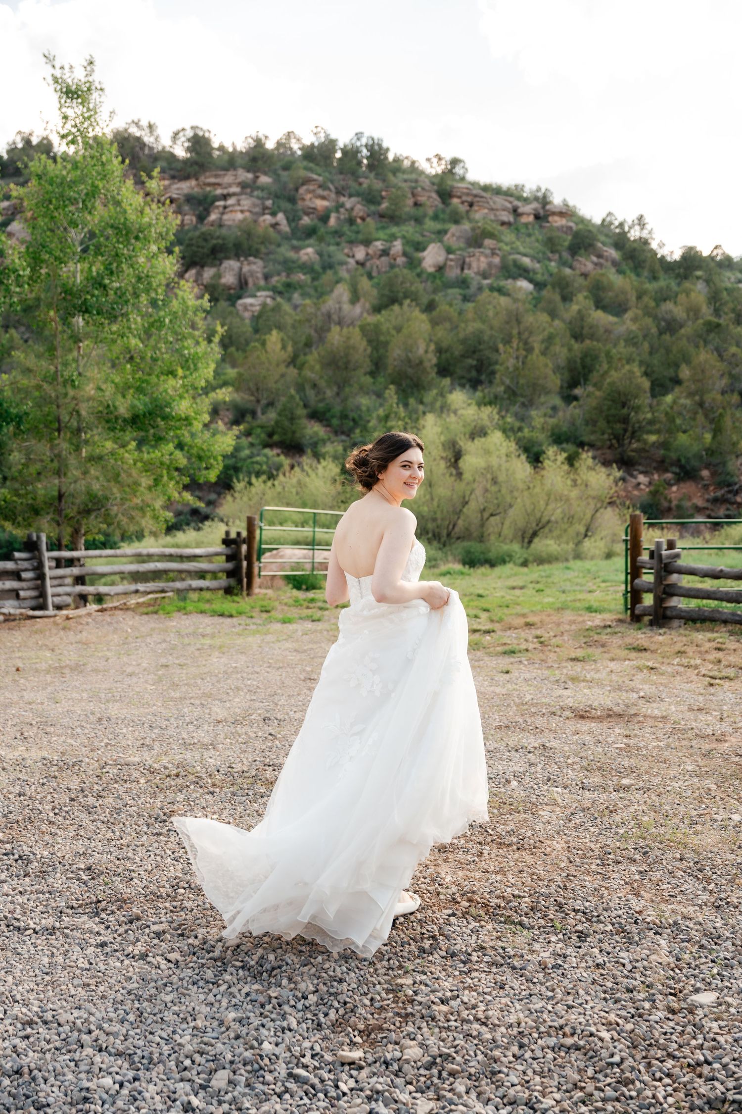 A flowing white wedding dress twirls gracefully against a mountainous backdrop.