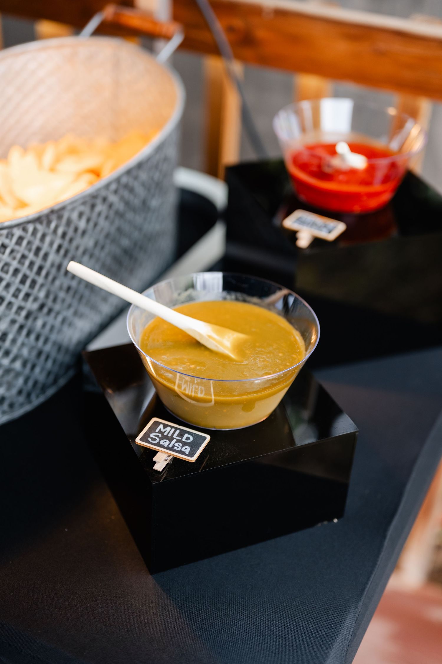 Colorful cocktails served in modern glassware on black serving trays at an event.