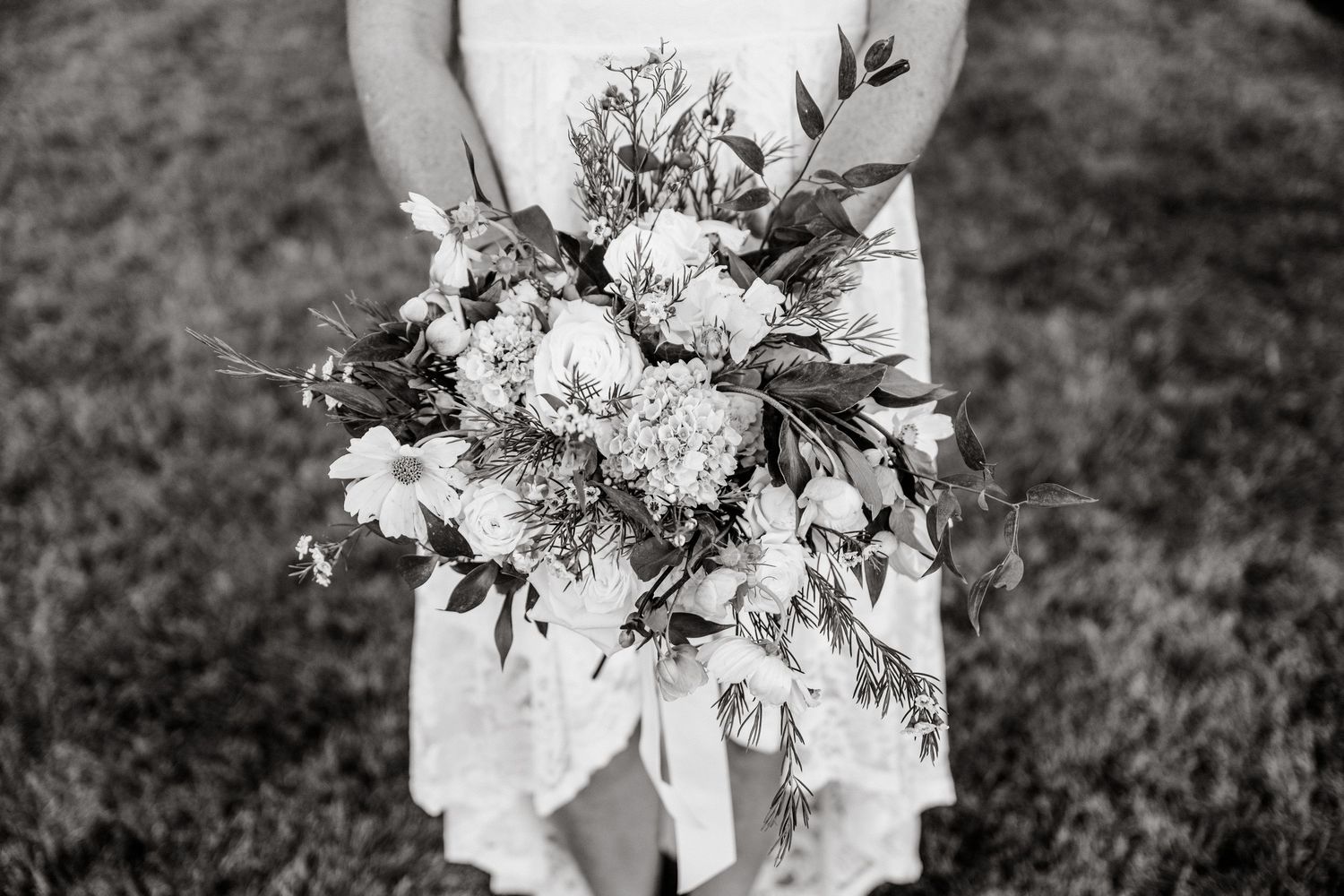 A collection of elegant white and pink wedding bouquets arranged in a row against a dark background.