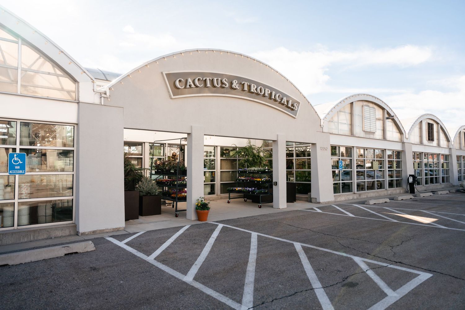 Art deco style storefront of Pastis restaurant with white arched facade and large windows in a commercial building exterior.
