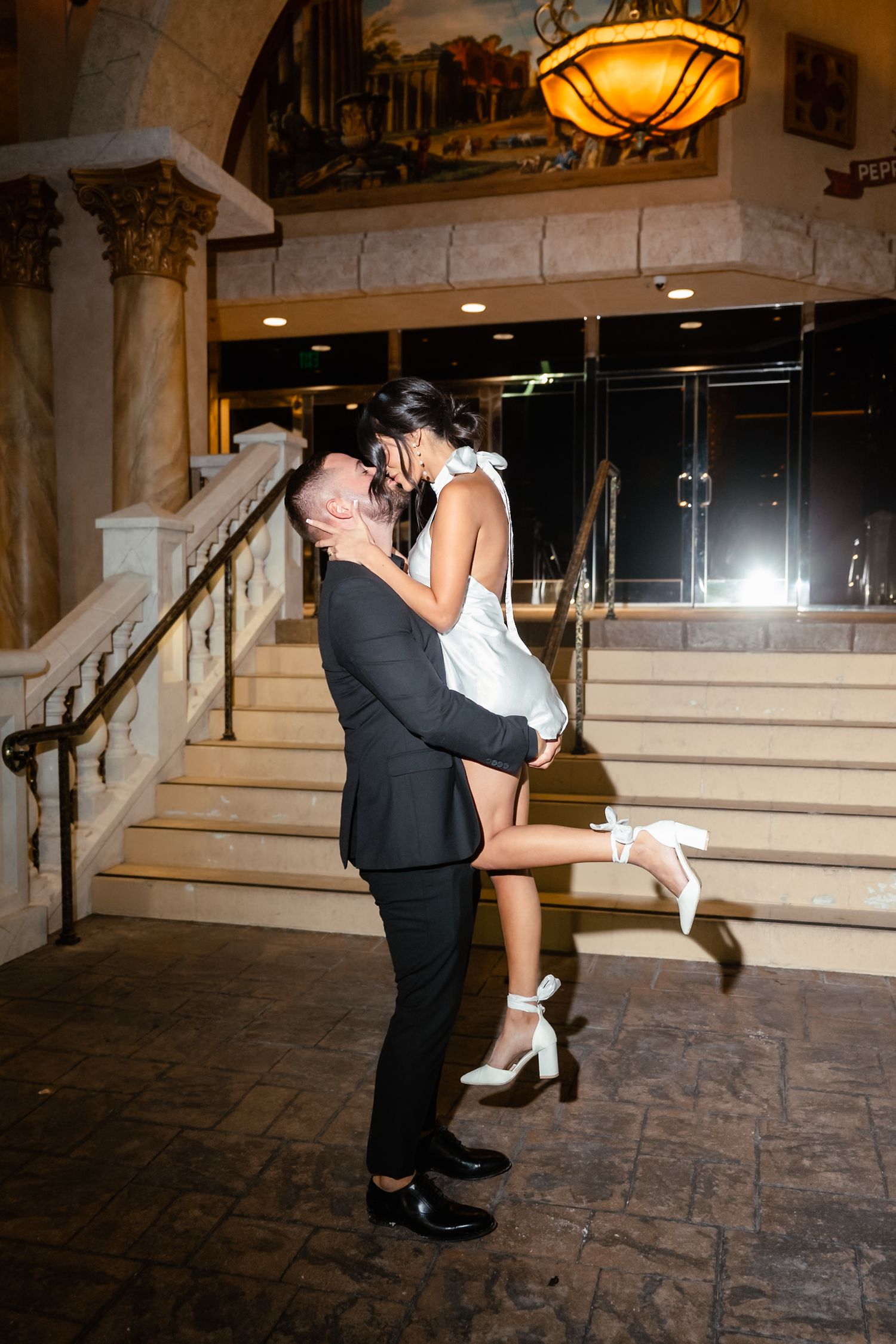 Dancing couple performs romantic dips in an elegant indoor venue with warm lighting.