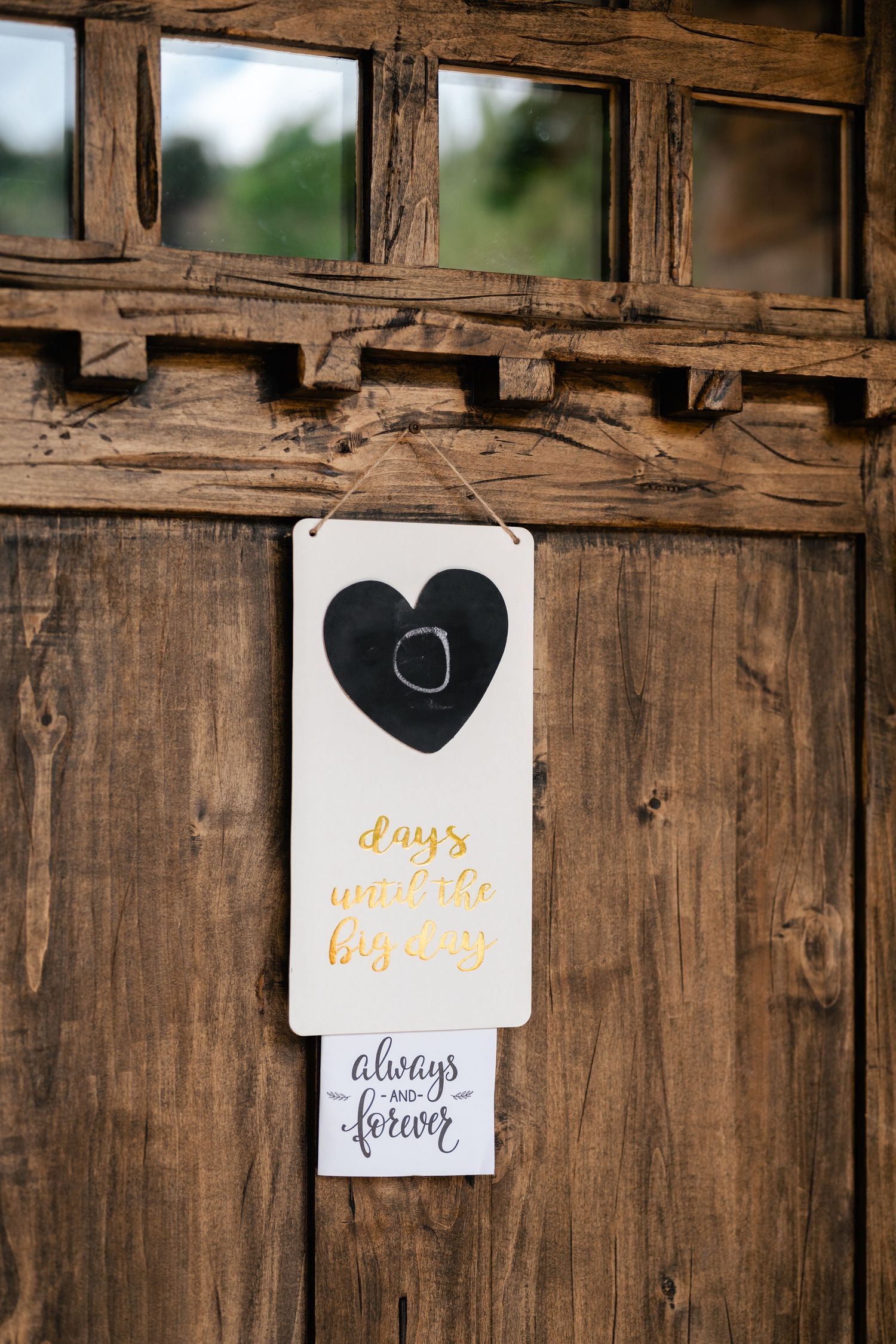 Rustic wooden wall decorated with romantic heart signs and calligraphy quotes for a wedding.