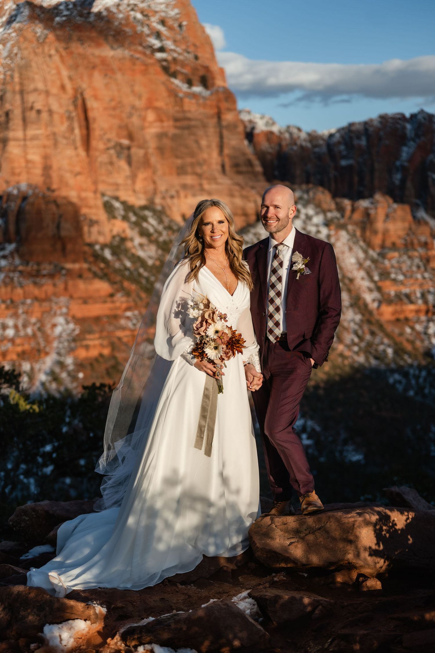 Dramatic wedding portraits with towering red rock cliffs in the background.