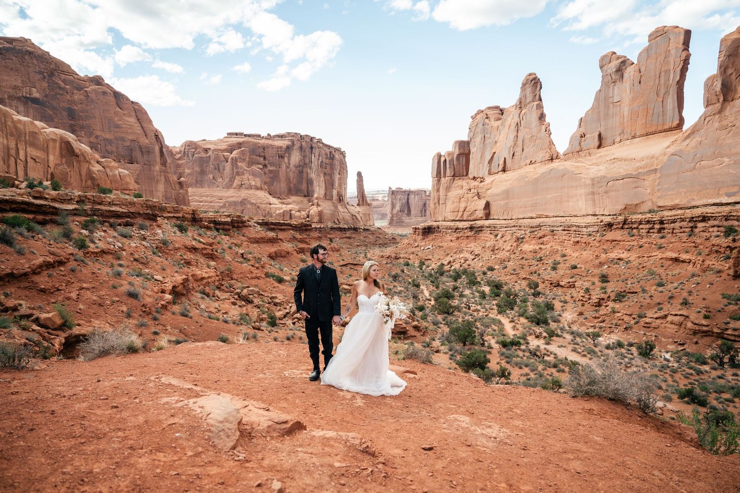 Panoramic view of red rock formations and desert landscape in Arches National Park during a wedding ceremony.