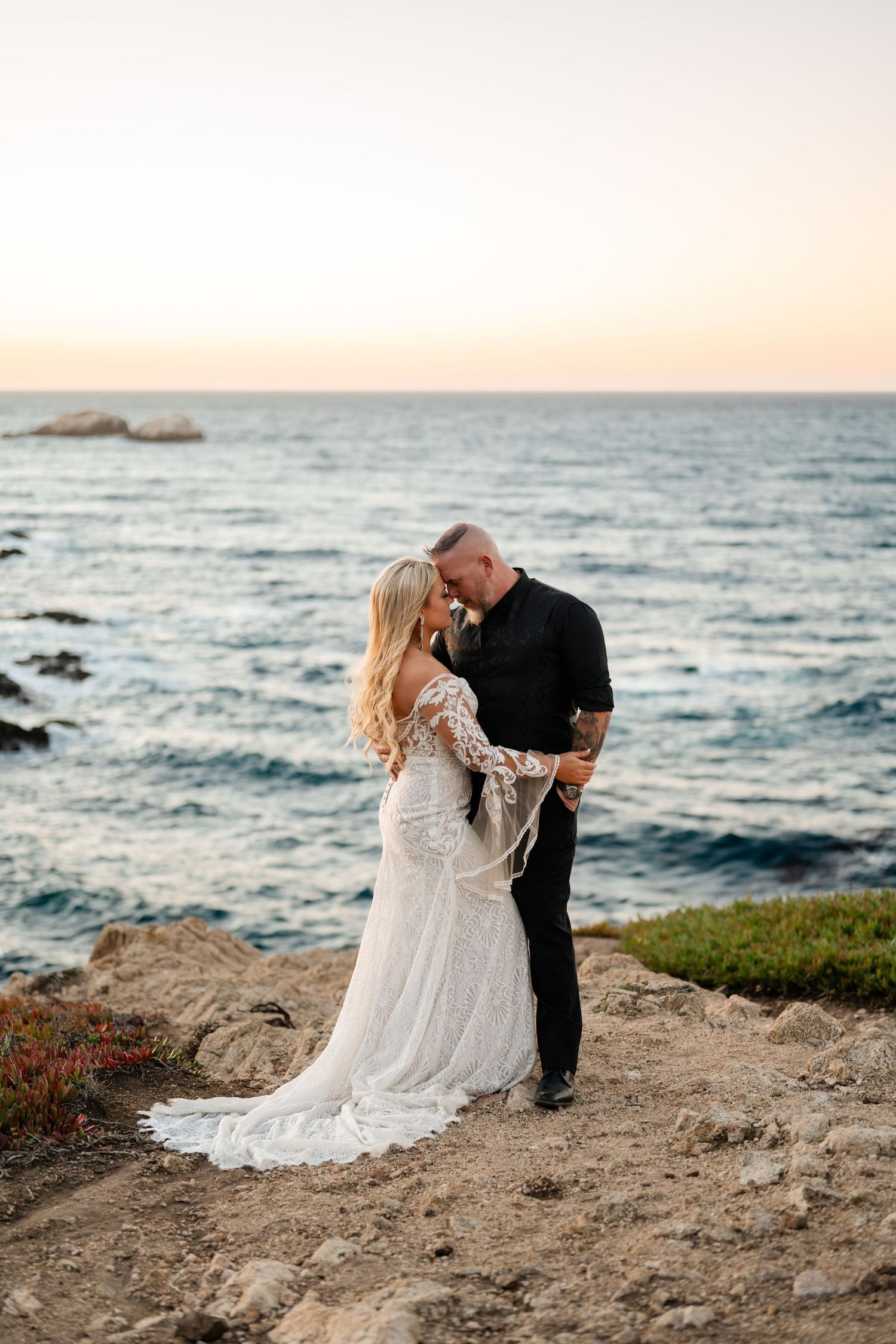 A coastal wedding portrait with crashing waves and sunset lighting.