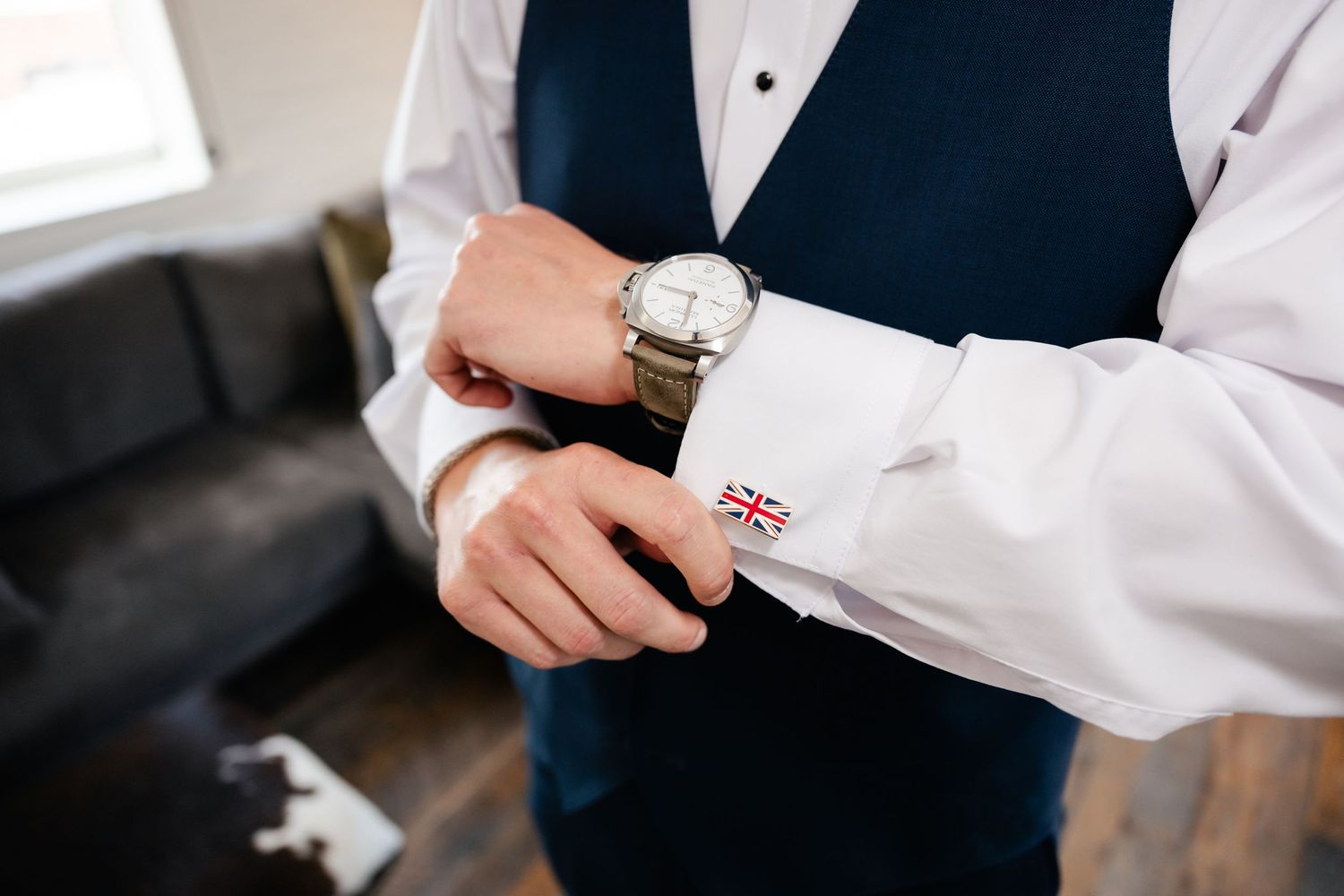 Close-up of formal attire showing white dress shirt, navy vest, and cufflinks.