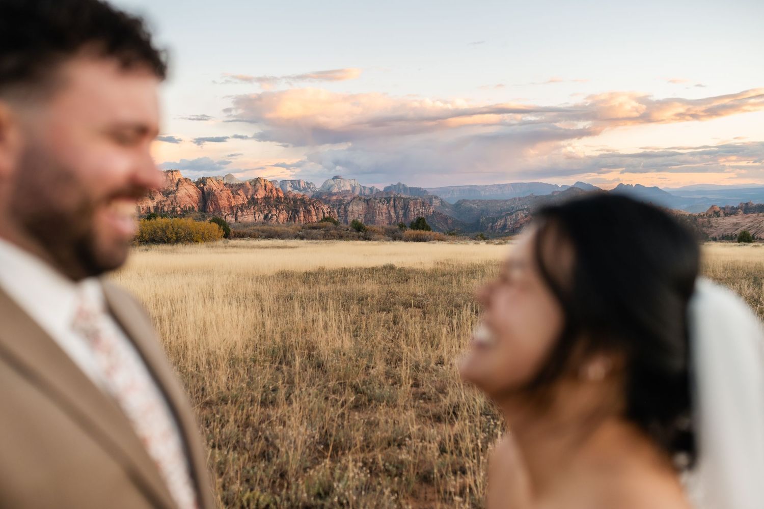 An intimate wedding moment captured against a mountain backdrop at sunset.