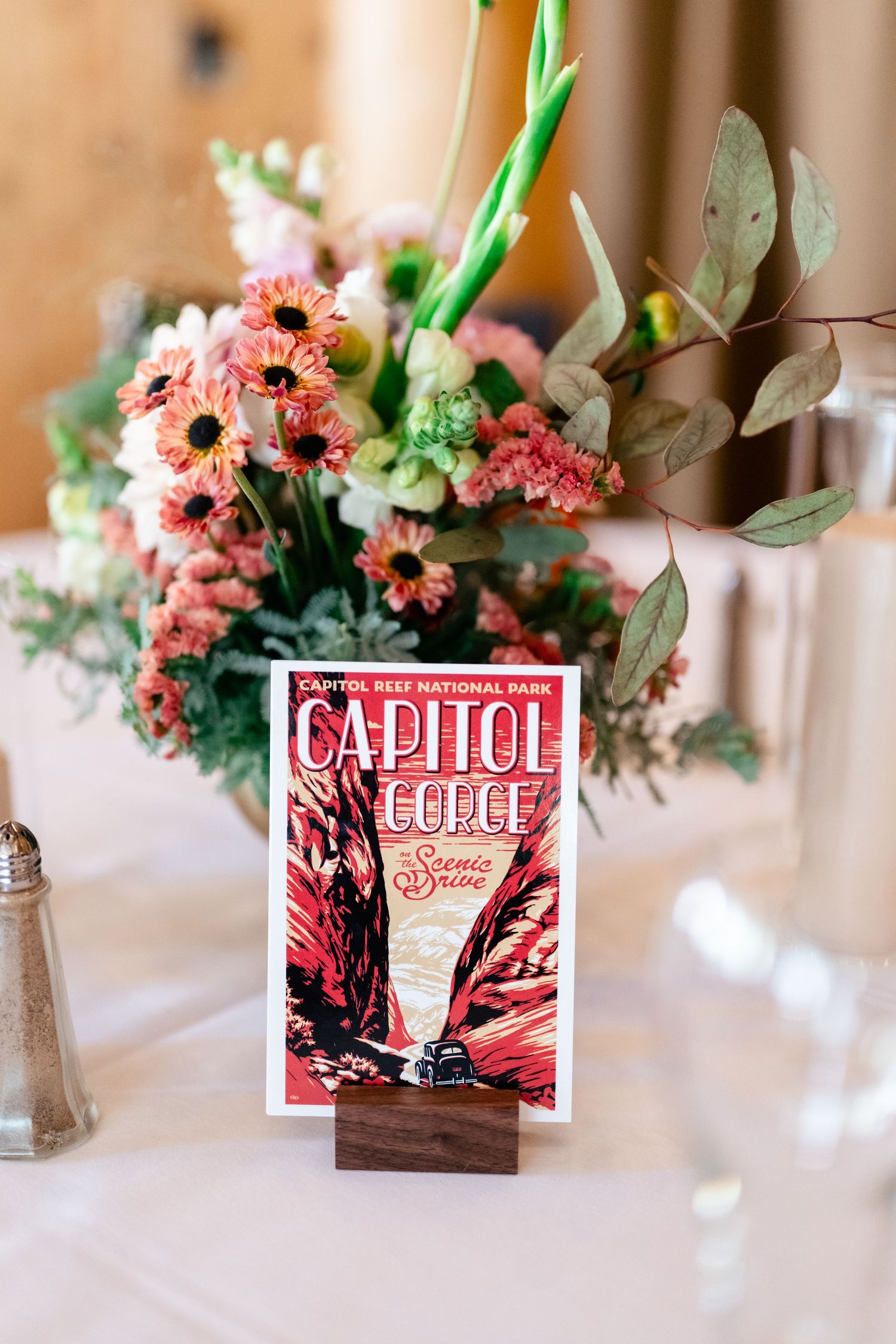 Wedding reception table centerpiece with pink flowers and vintage Capitol Records album display cards.