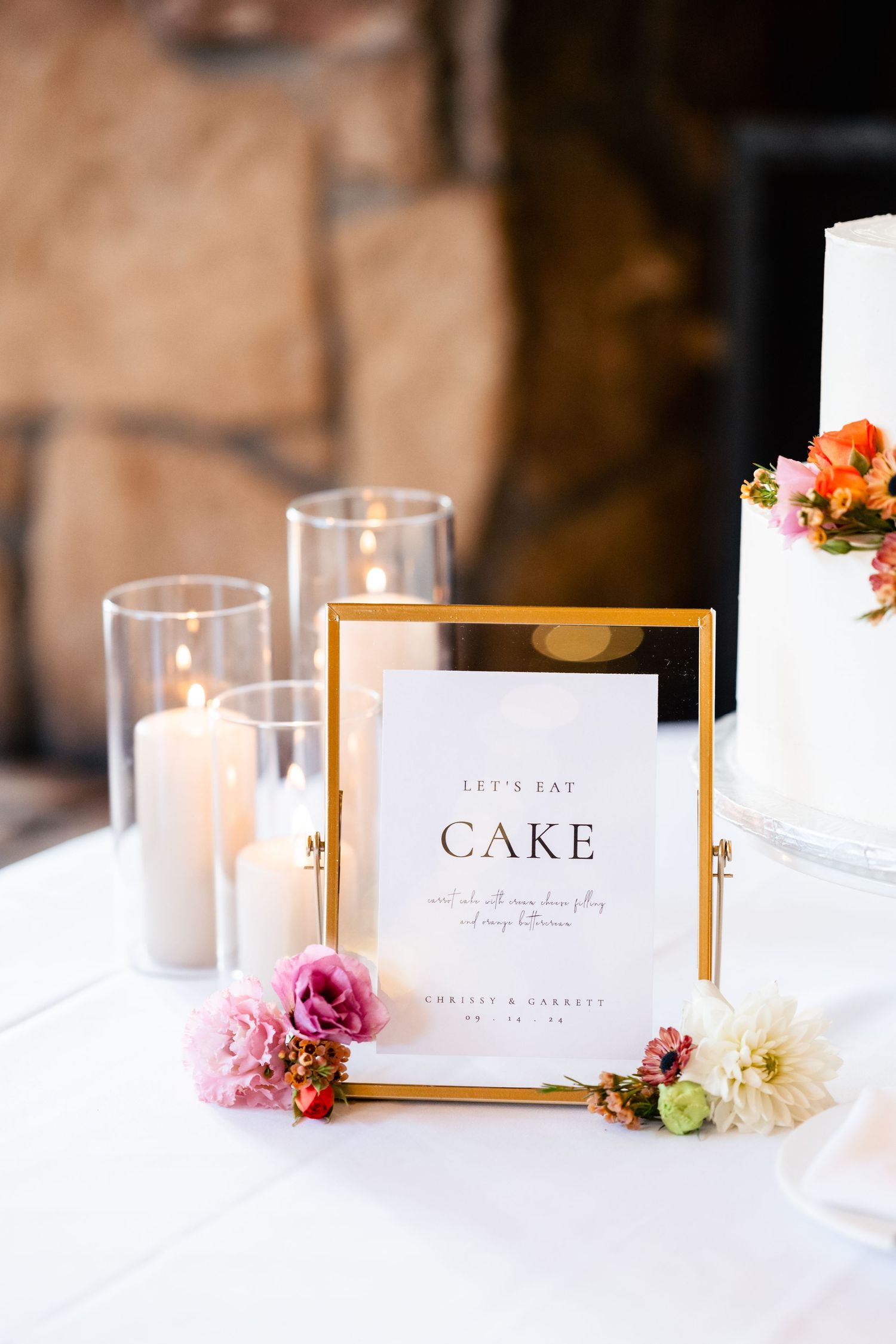 Elegant wedding reception table settings with gold frames and pink floral accents.