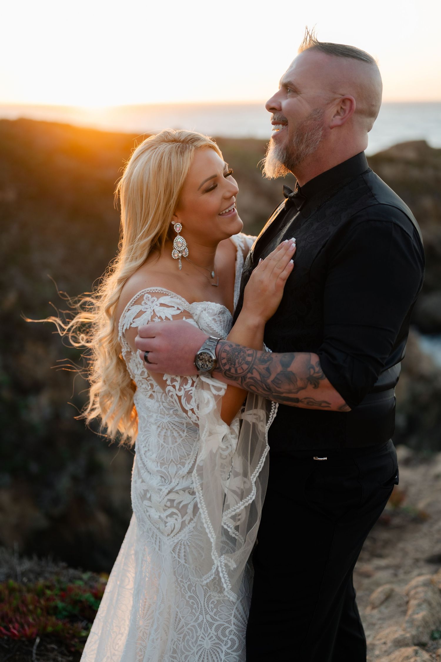 Intimate wedding moment captured during golden hour on coastal cliffs.