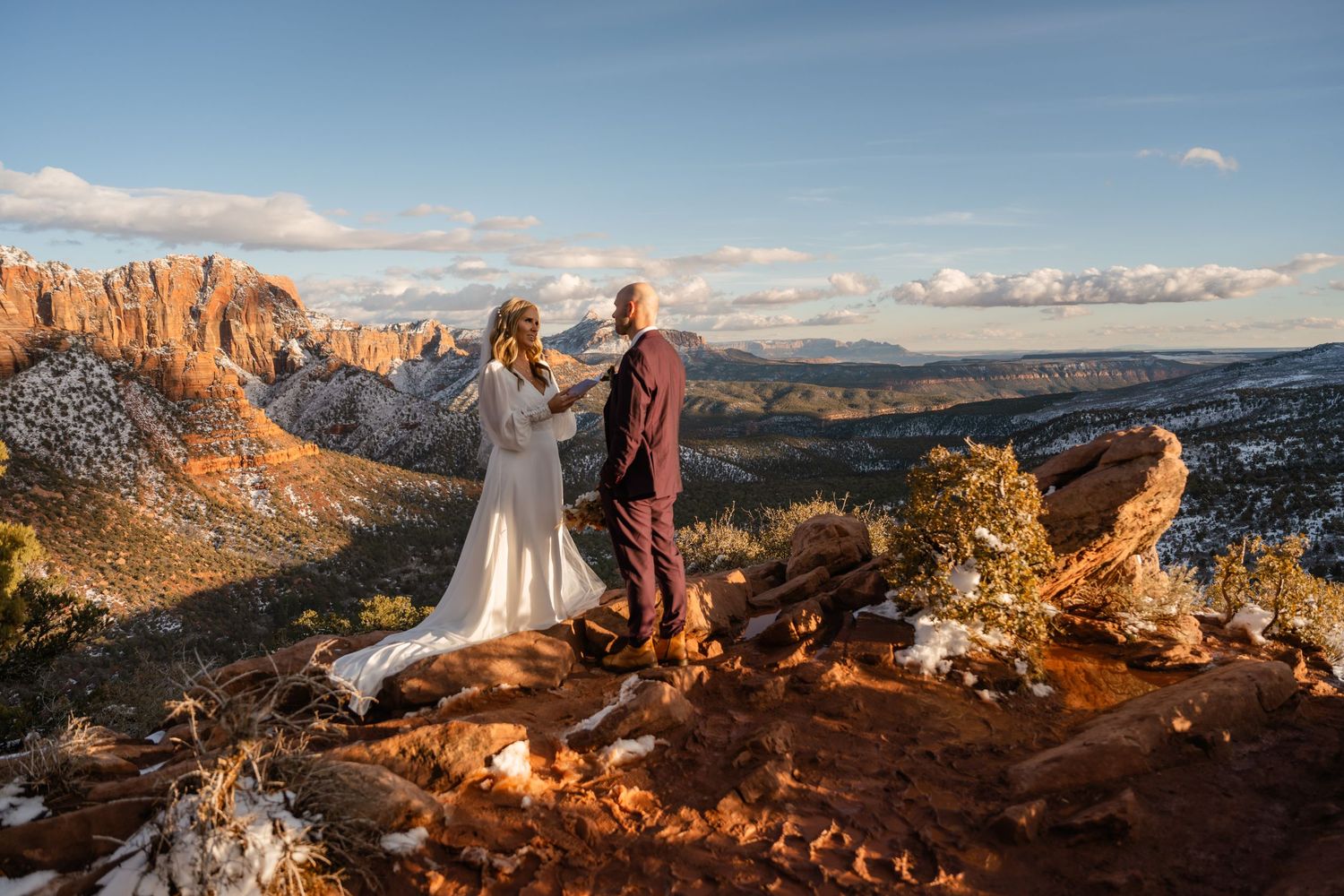 Dramatic sunset view of red rock cliffs and canyons in Zion National Park with golden light illuminating the landscape.