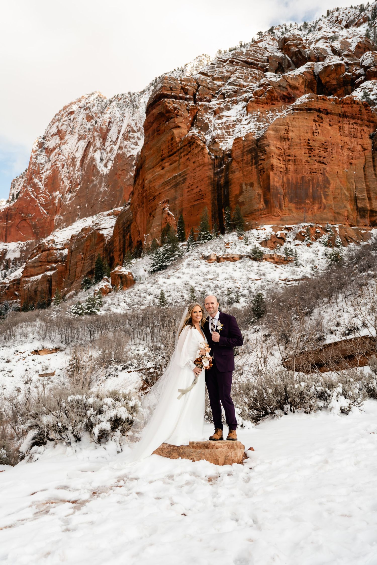Wedding photography sequence showing a couple walking through snowy terrain with red rock formations.