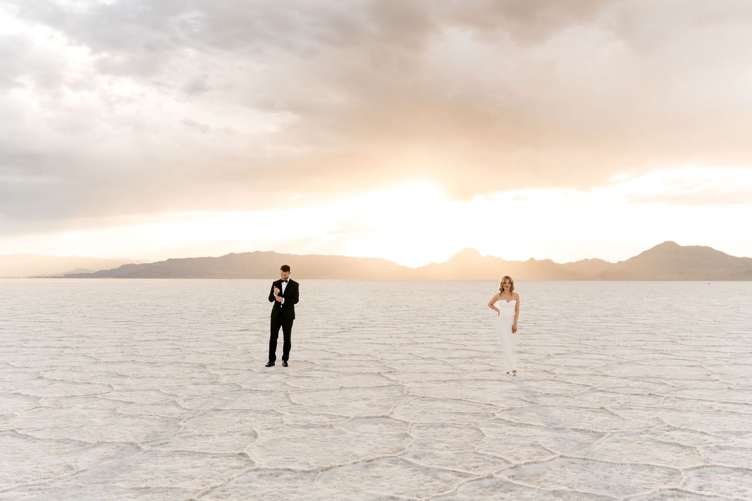 Silhouettes of people walking on the vast white salt flats of Bonneville during a dramatic sunset. Salt Flats Photographer.