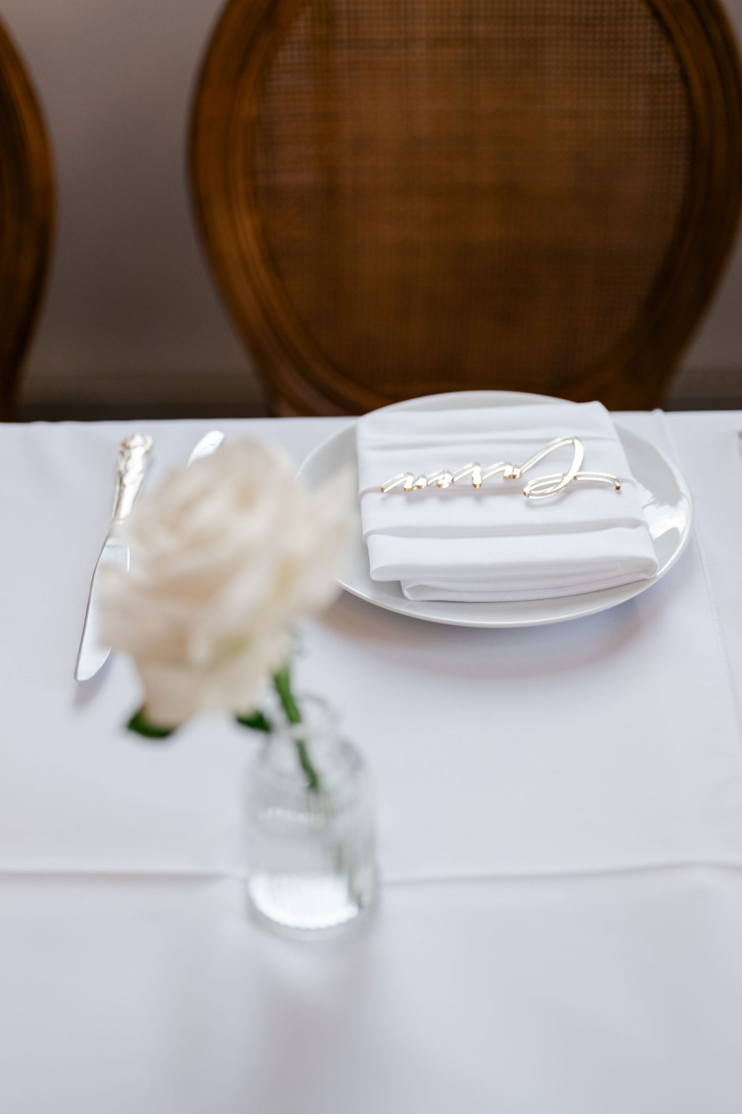 White table settings with folded napkins and wooden barrels in the background at an elegant reception.