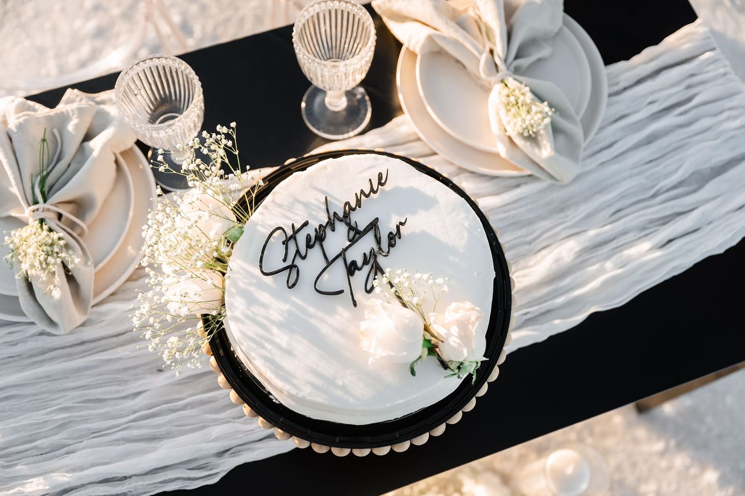 Wedding details including delicate white flowers and decorative items arranged on a dark surface.