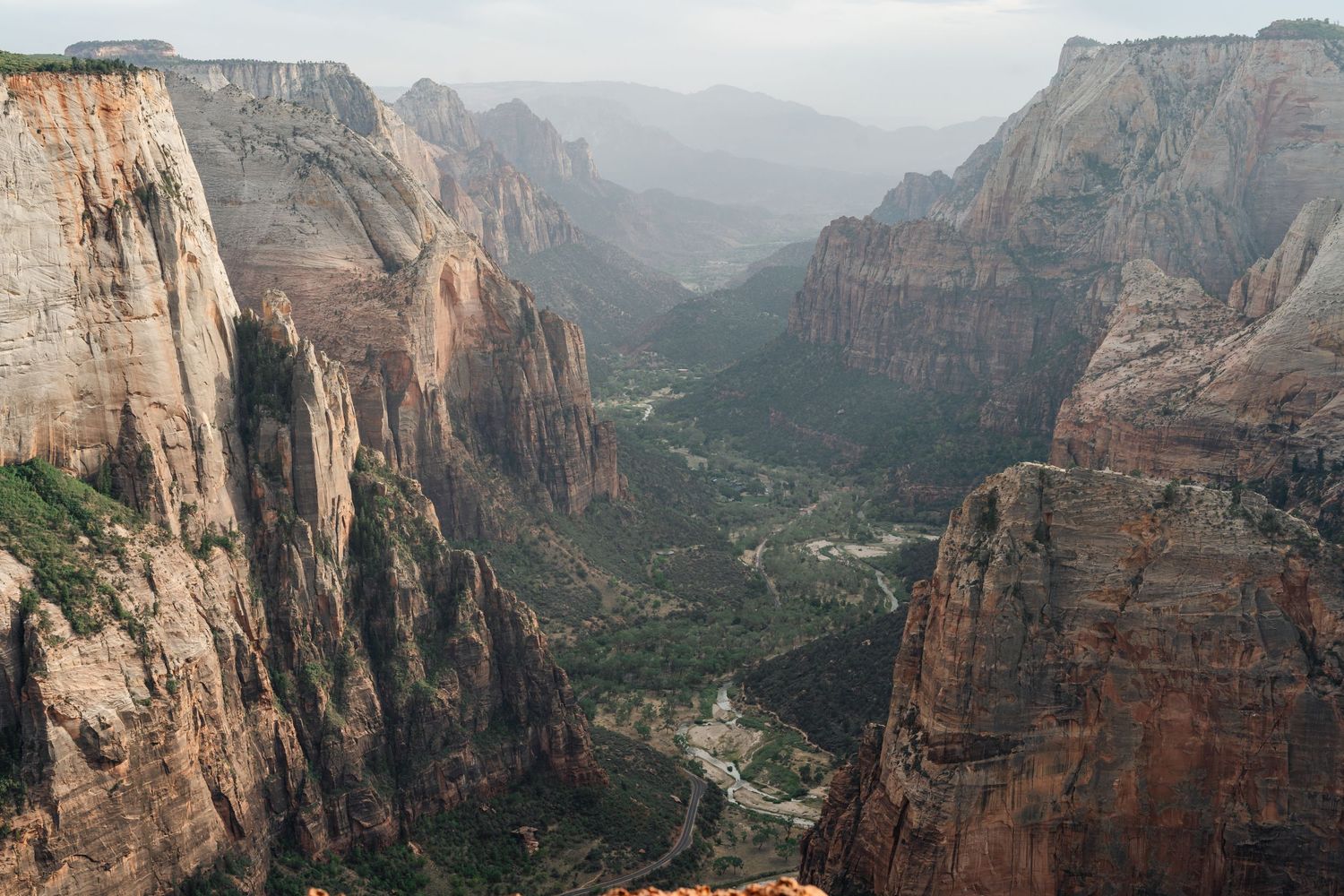 Aerial view of Zion National Park's dramatic canyon with towering red rock cliffs and winding river valley below. Zion Wedding Photographer.