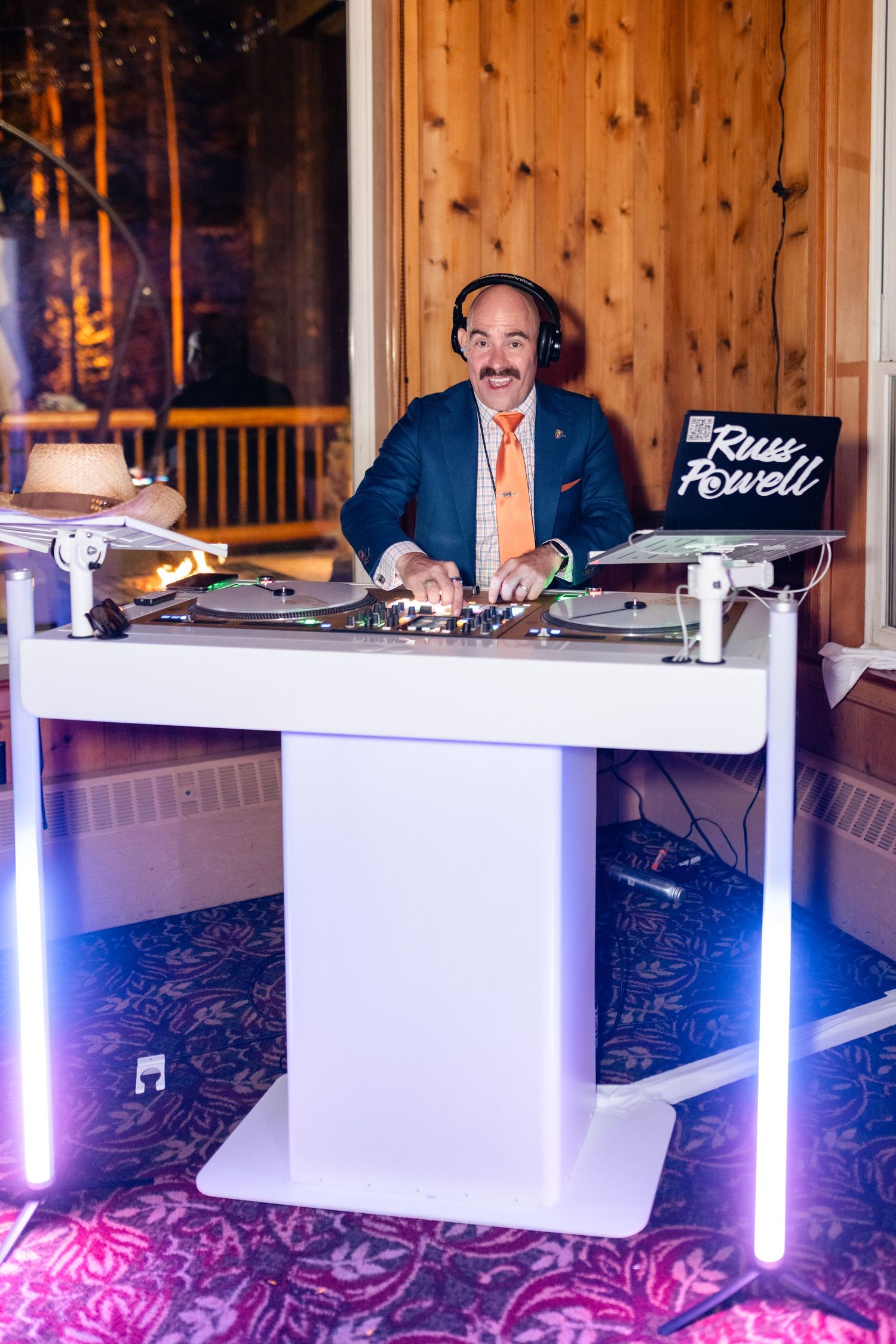 DJ booth setup with modern white LED-lit table and professional equipment at an event venue. Utah Wedding Photographer. Park City Wedding.