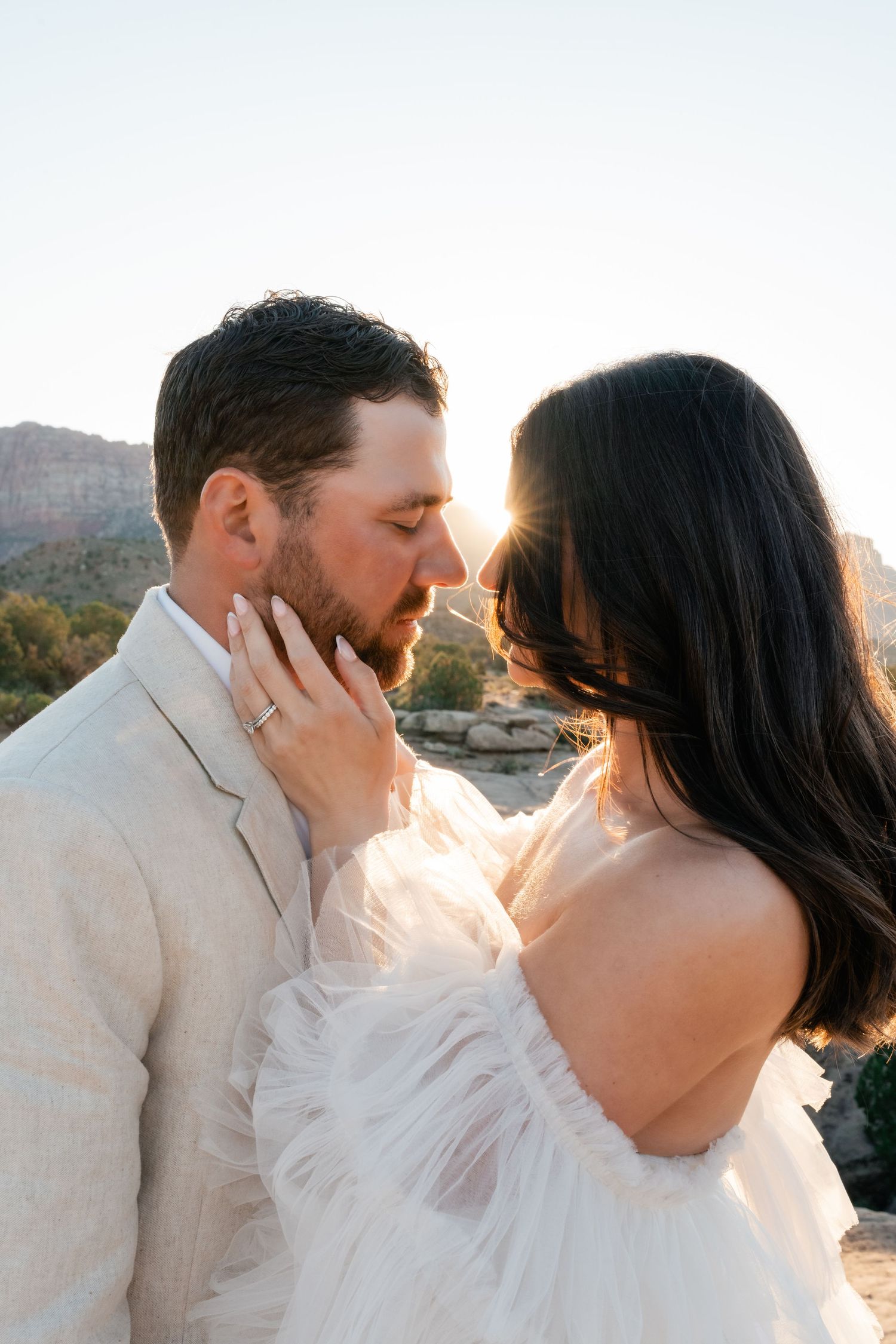 A romantic sunset wedding photo sequence shows a couple sharing intimate kisses against a desert mountain backdrop. Zion Weddings.