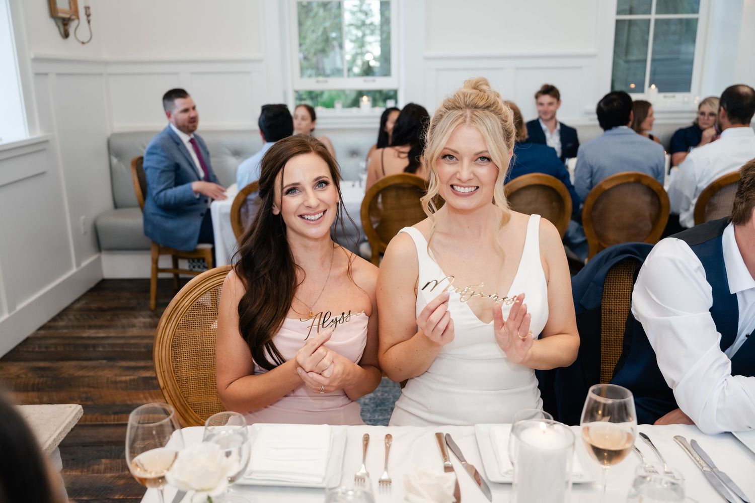 Wedding guests dining and socializing at elegant reception tables.