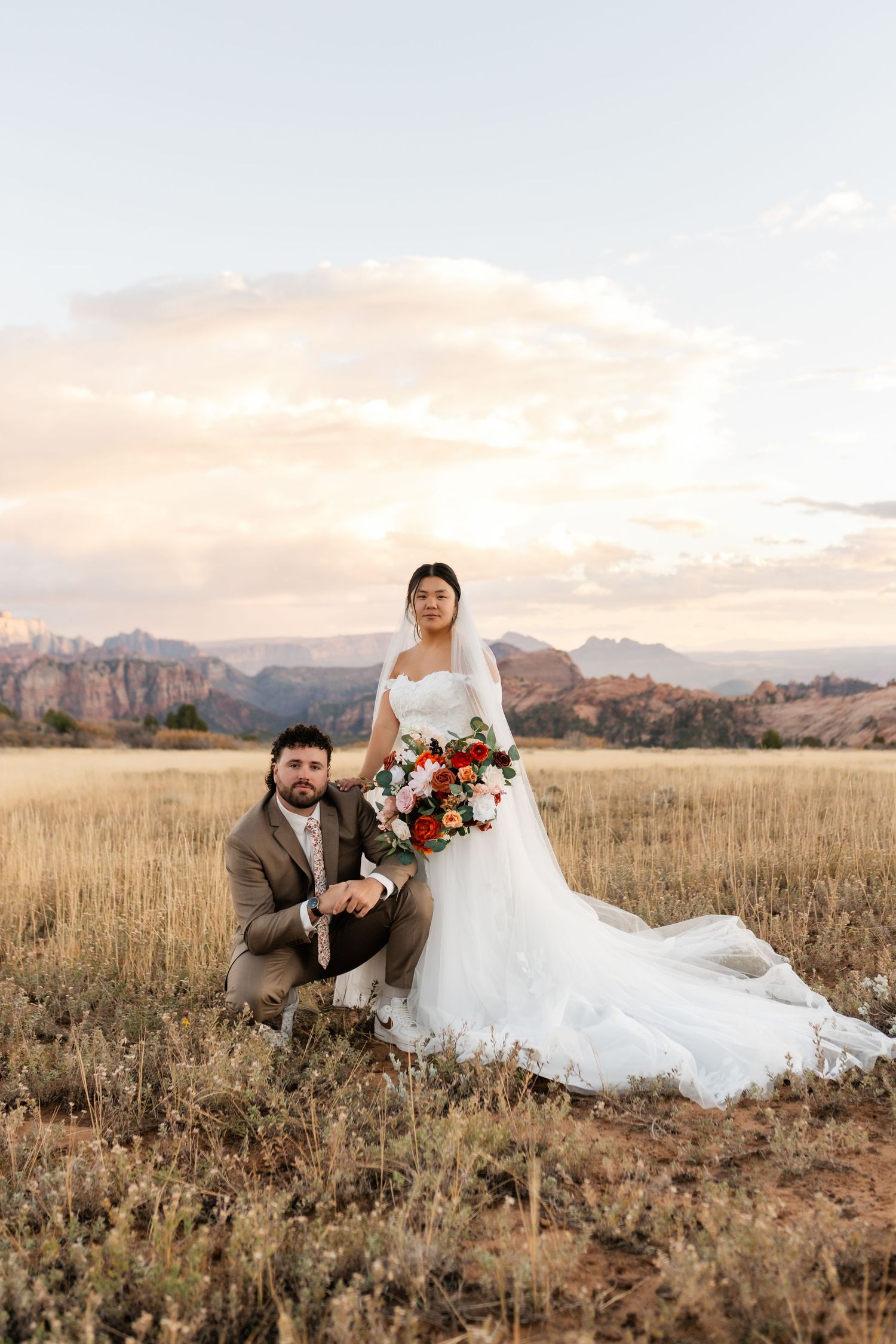 Romantic sunset wedding portraits in mountain meadow with warm evening light.