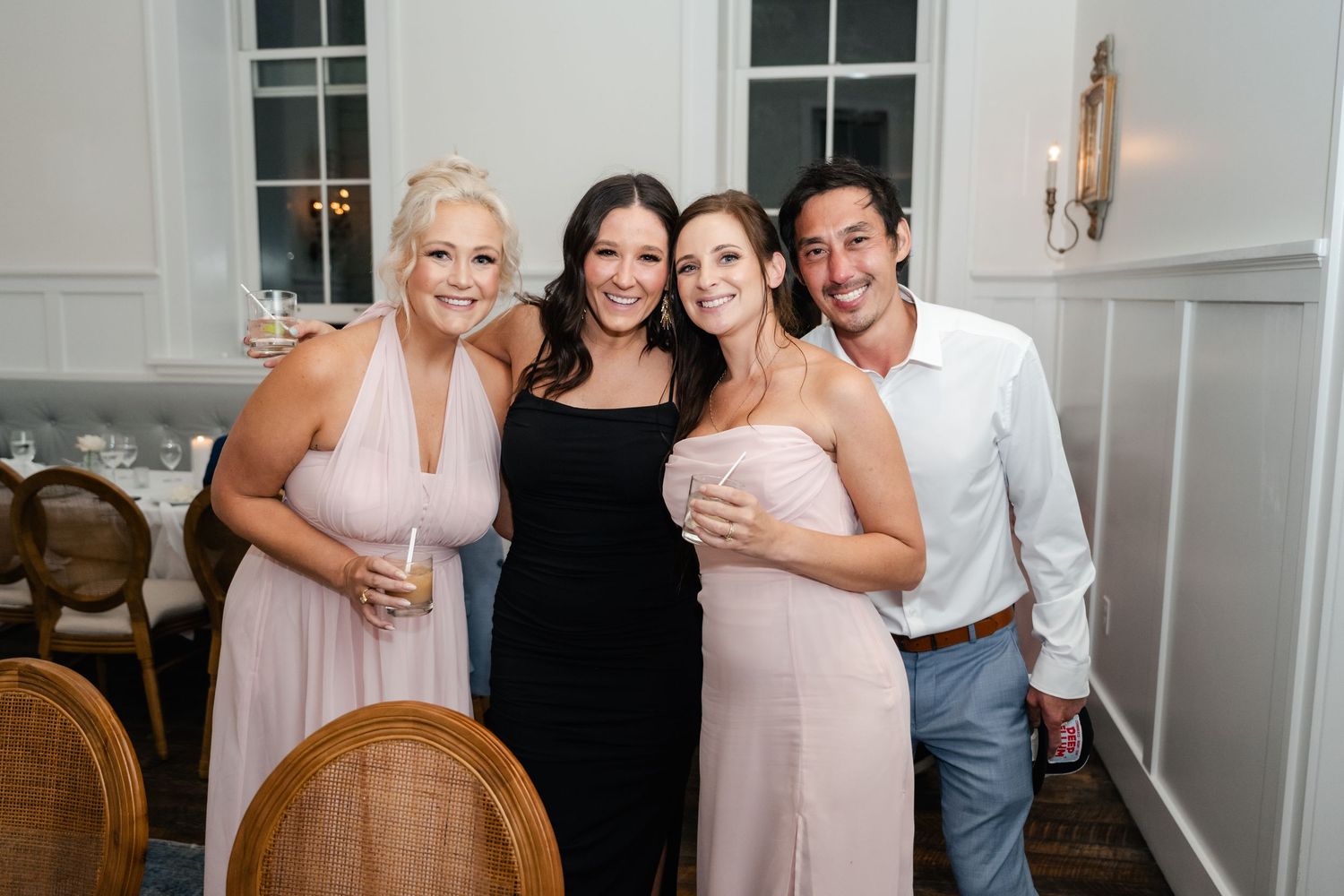 Four friends pose together smiling at an elegant wedding reception during a Park City wedding weekend at the Washington School House Hotel.