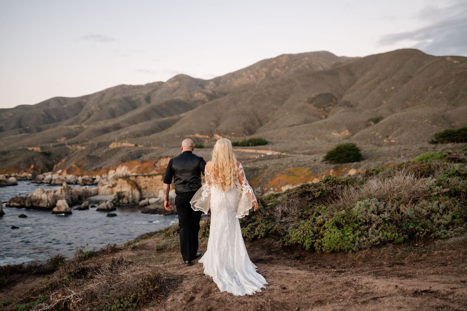 Coastal wedding portraits with rolling hills and ocean views at golden hour.
