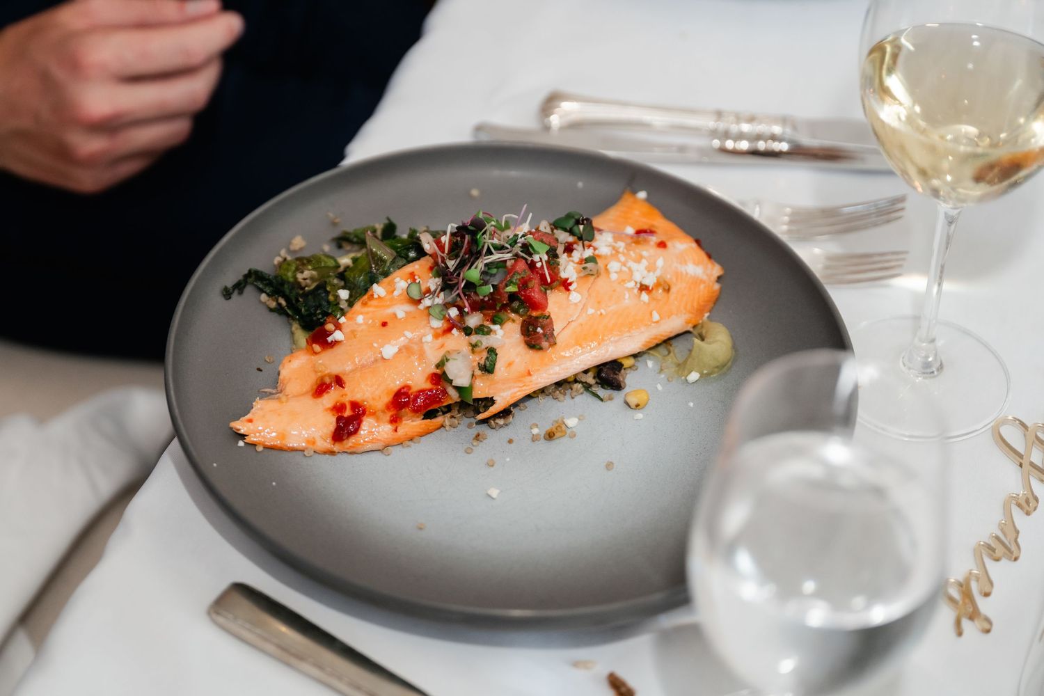 Gourmet salmon dish plated elegantly on grey ceramic plate.