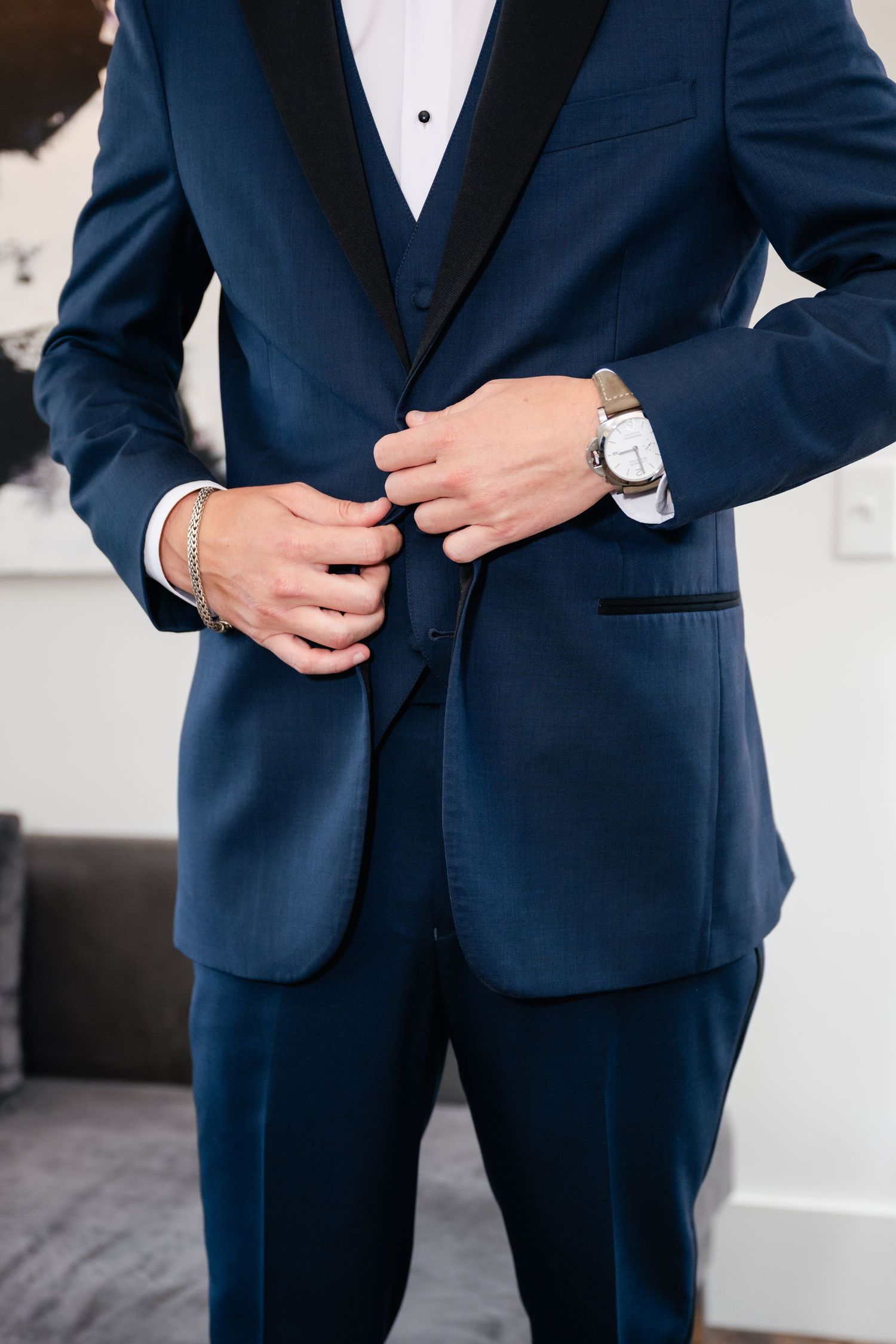 Close-up details of navy blue tuxedo jacket and accessories.