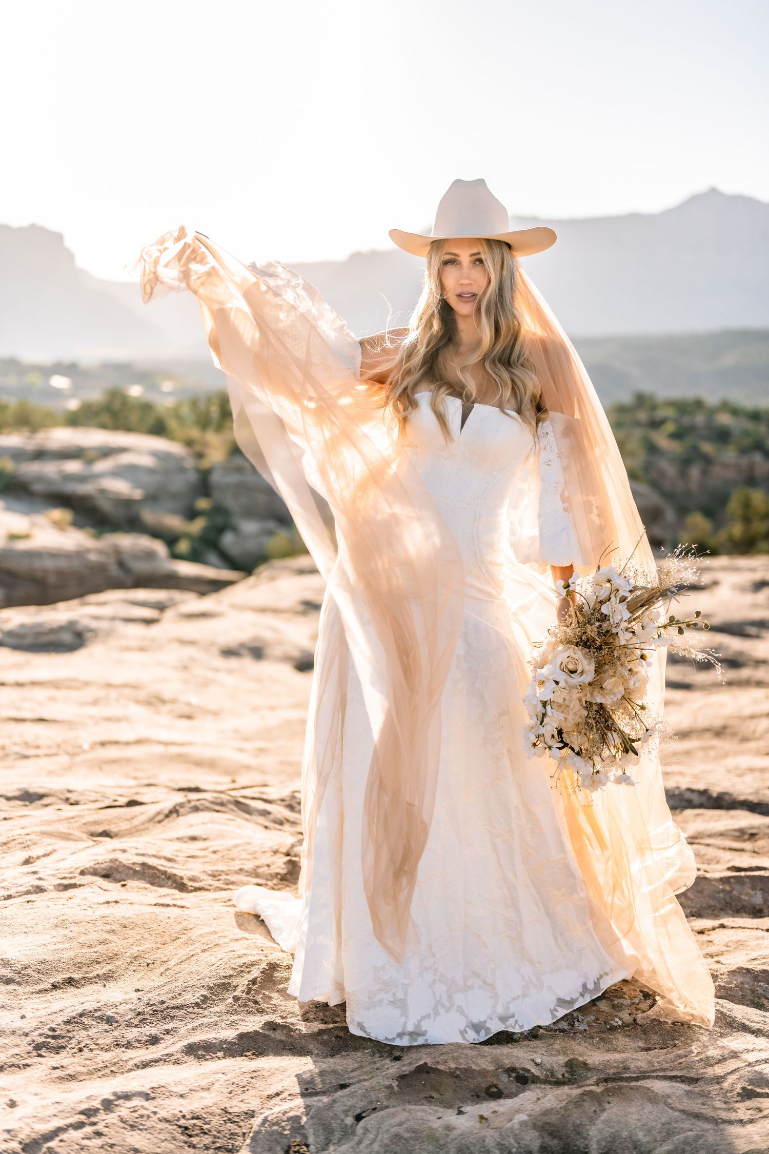 Utah elopement photographer takes breathtaking desert sunrise bridal session with a stunning bouquet and cowgirl hat.