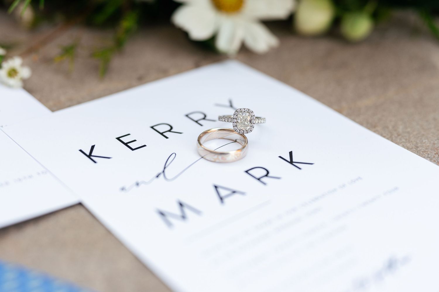Close-up view of a handwritten wedding invitation with elegant calligraphy and floral details.