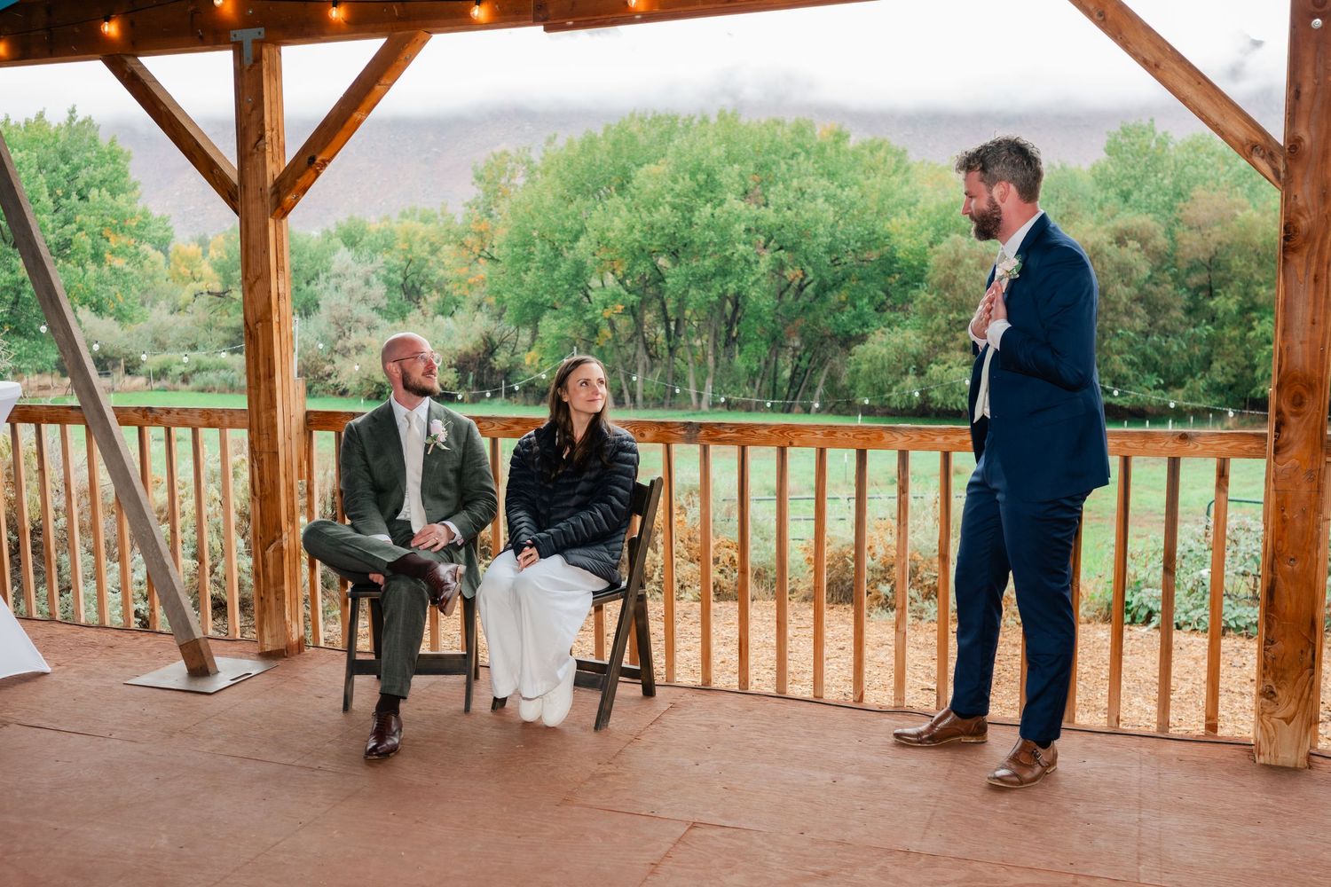 Guests gathered on a wooden deck with mountain views during an outdoor celebration.